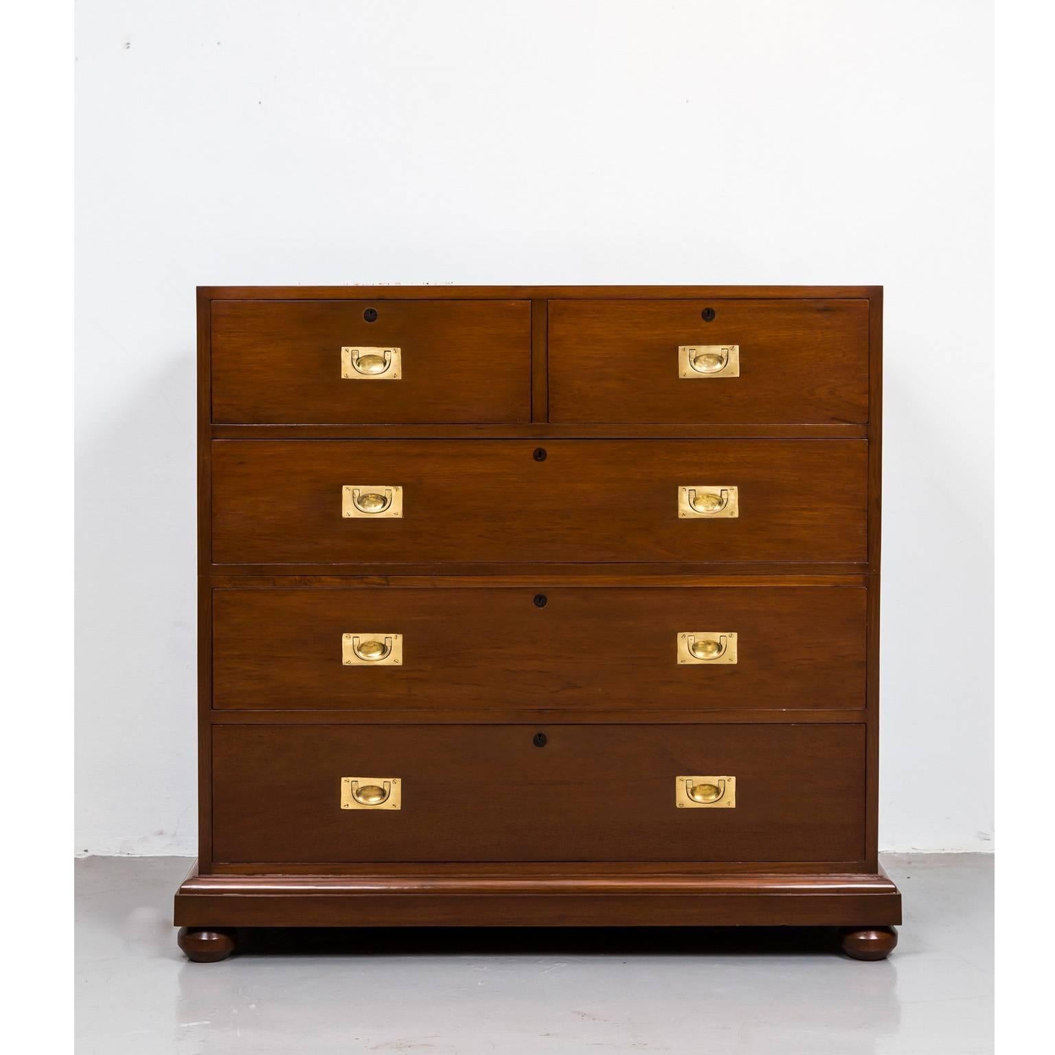 A British Colonial Campaign chest of drawers made of teakwood. Like the majority of Campaign chests, the present example has brass lift handles on the sides and can be split in two parts for ease of transport. The top section has two short drawers