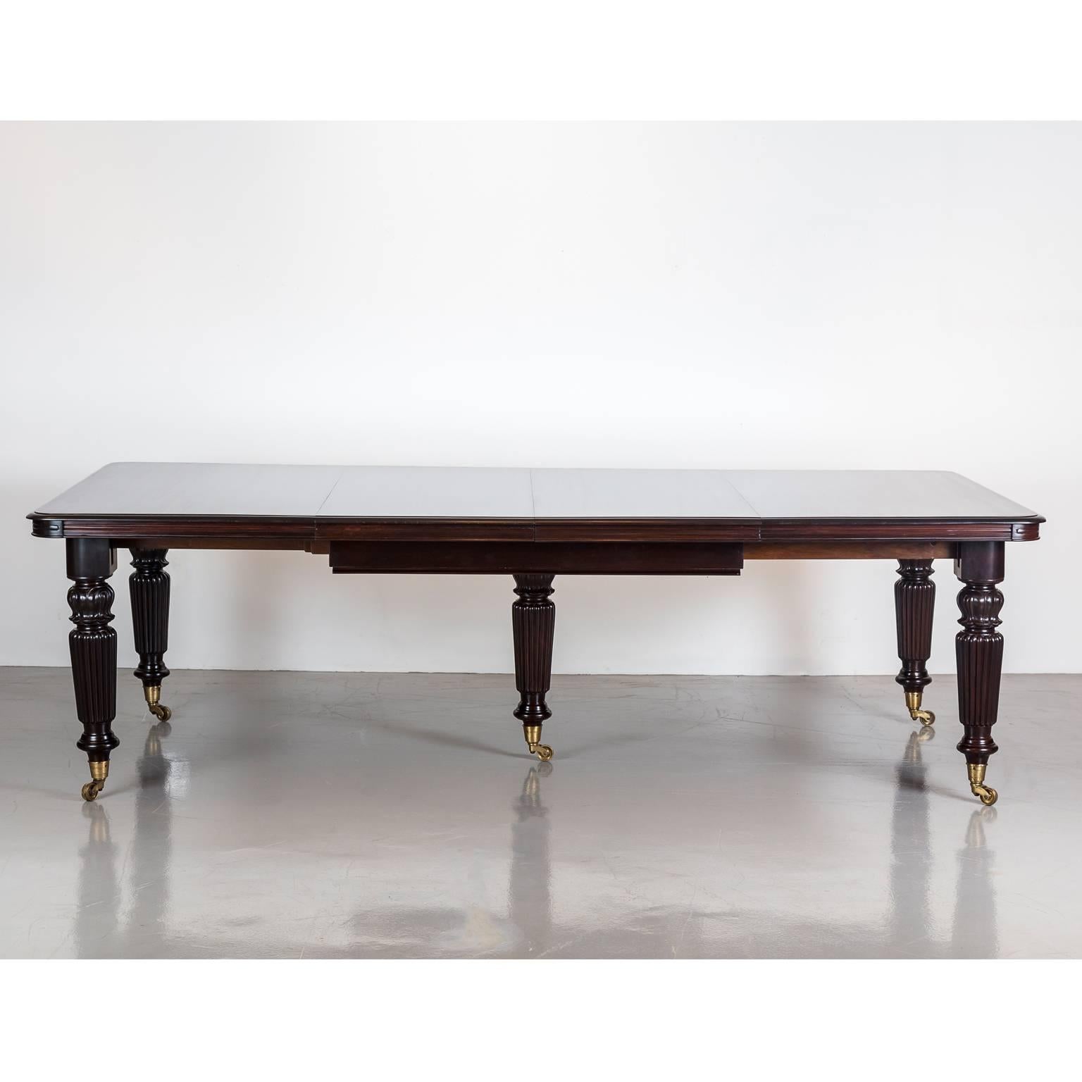 A stunning British Colonial rosewood extending dining table. The top with a deep moulded edge and rounded corners. The table has a telescopic under-frame that extends via a winding mechanism, which allows the table to be extended while the center