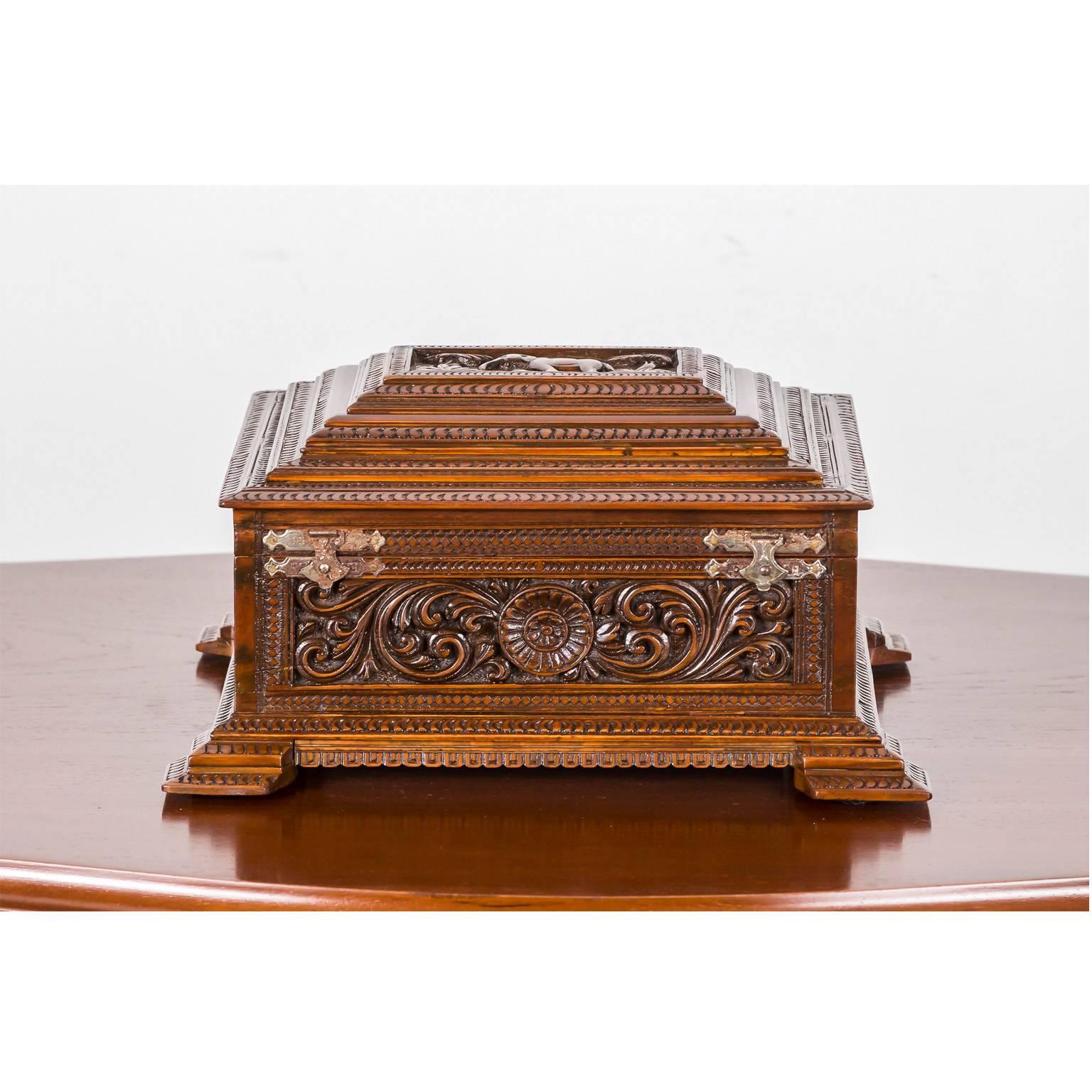 A gorgeous British colonial dome-shaped box made of sandalwood, beautifully and profusely carved on the four sides with floral designs. The lid is carved with an image of an elephant, flanked by two palm trees. 
The box opens to a plain interior