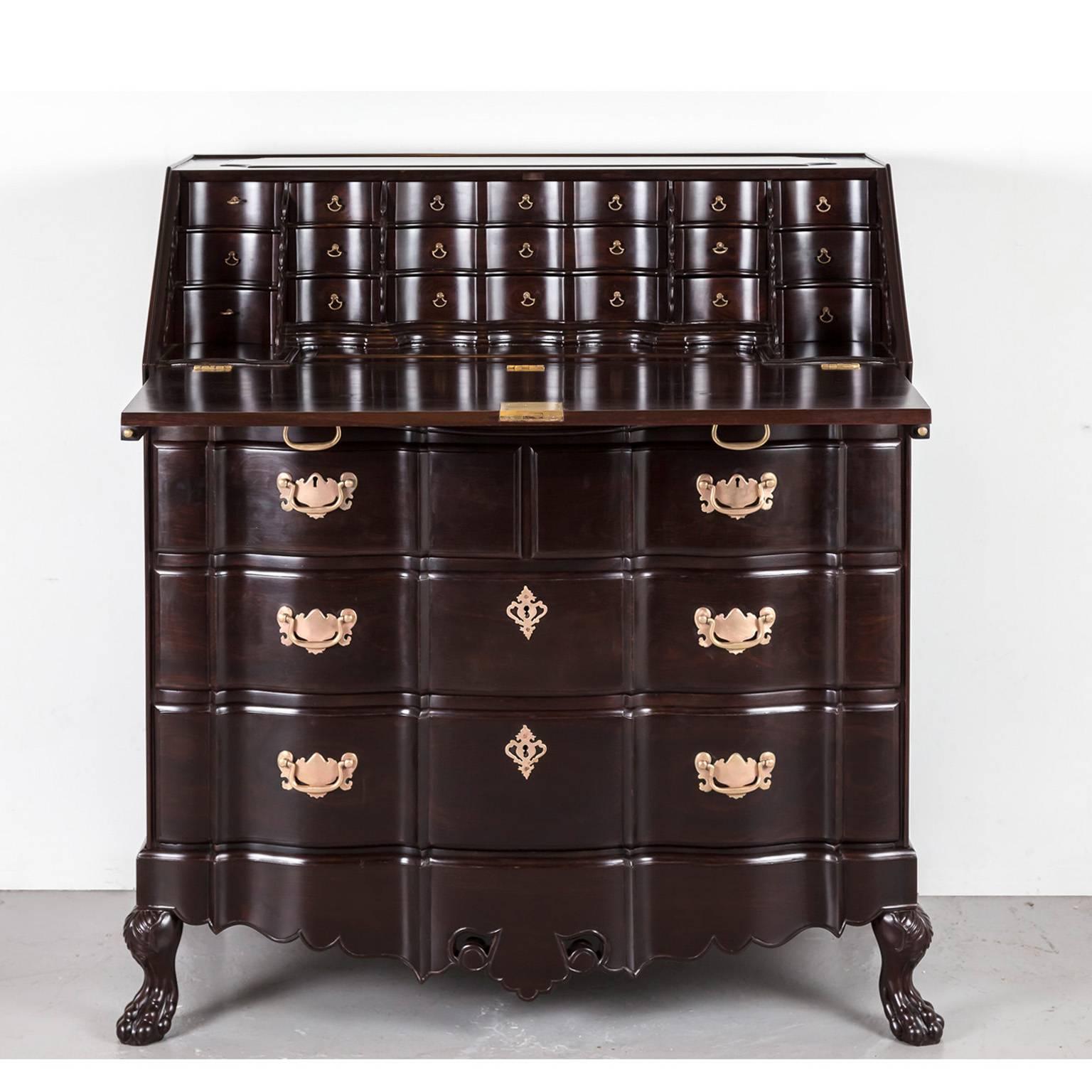 A magnificent British colonial drop front bureau in rosewood with original brass carrying handles on the sides. 
It has a beautiful stepped and serpentine shaped interior with small drawers that are segmented over three rows. The larger sized