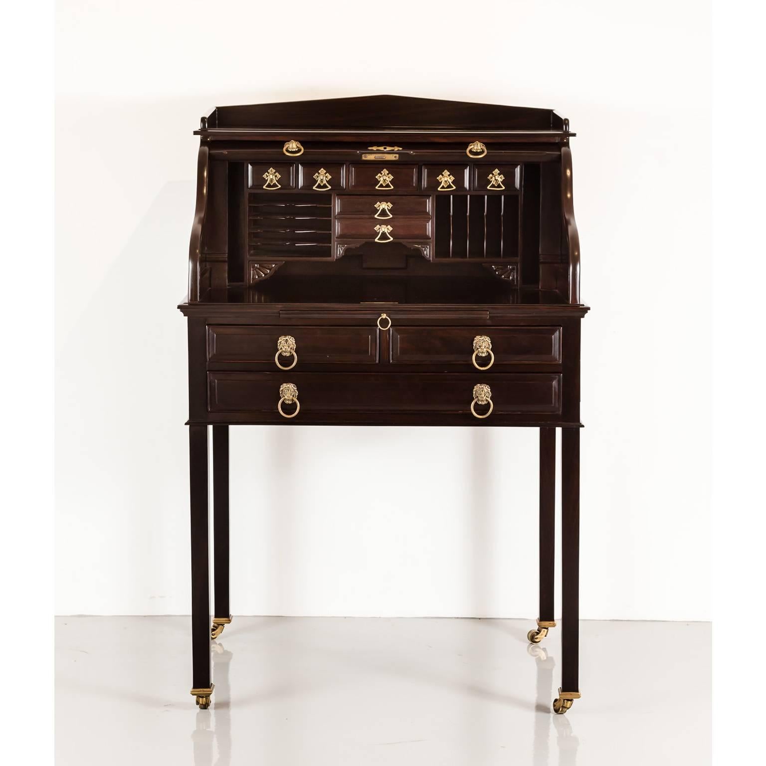 A unique British colonial rosewood secretaire which has cleverly constructed hidden trick-openings for its front drawers. 
The desk has a shaped back above a rectangular moulded top and a roll top fall front. The top opens to reveal a fitted