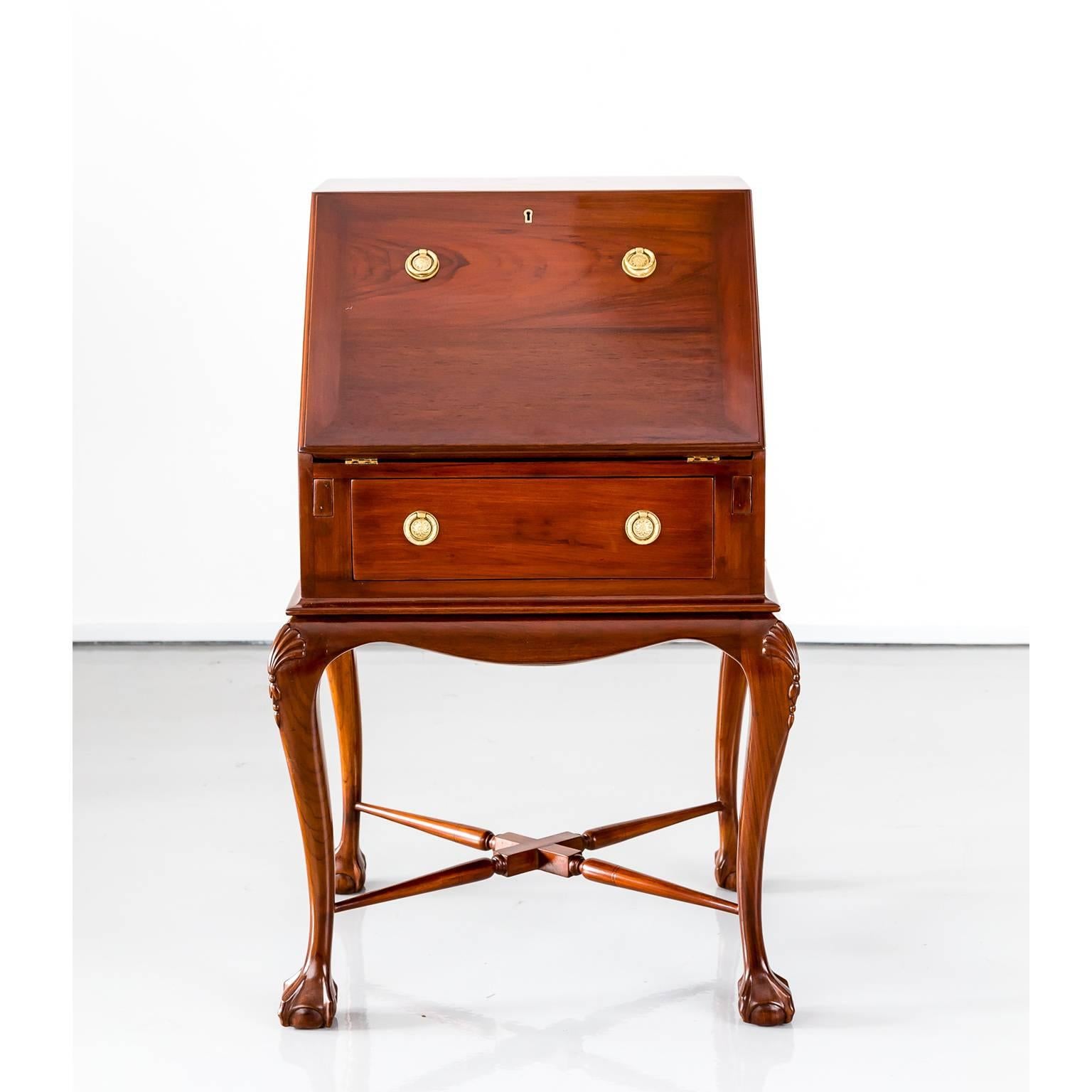 A nice, unusual size British Colonial drop front desk in teak wood. 
The slanted top opens to form the writing surface which has a new black leather inset. The fitted interior features two one drawer and several document compartments. 
It stands