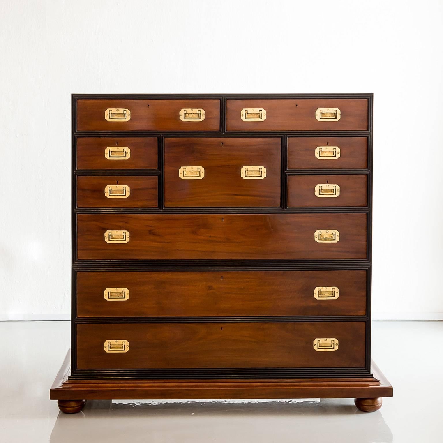 A beautiful British colonial camphor secretaire chest, the top portion with six short drawers and one central secretaire drawer above one long drawer. 
The secretaire drawer pulls out and drops down to reveal a writing surface and a fitted interior