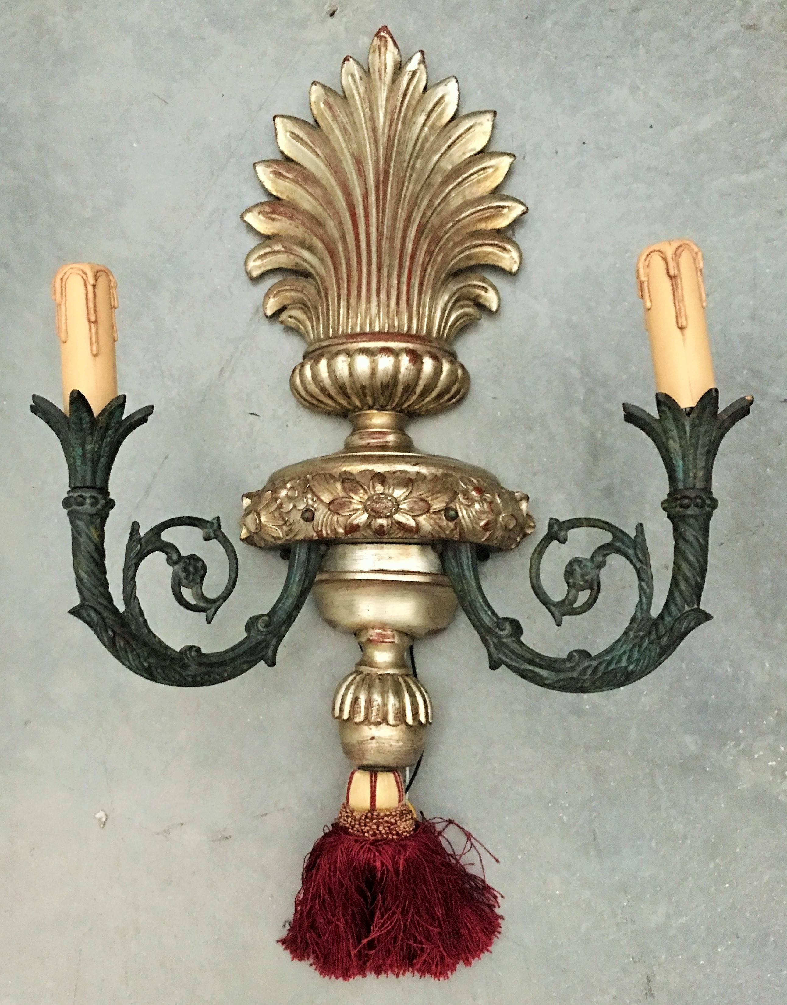 Pair of bronze two-lights Caldwell sconces with urn-shaped backplate. Original patina. 
Beautiful and elegant pair of Italian wood and iron sconces.
