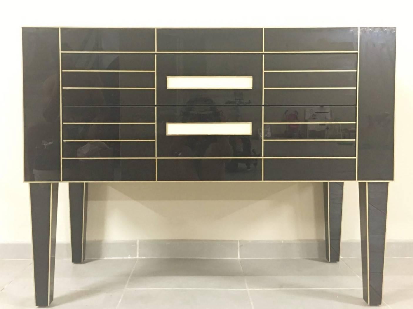 Beautiful and elegant black mirrored commode. 
Spectacular ivory glass handle.
Two-brake drawers.
Oakwood furniture sheathed glass.
  