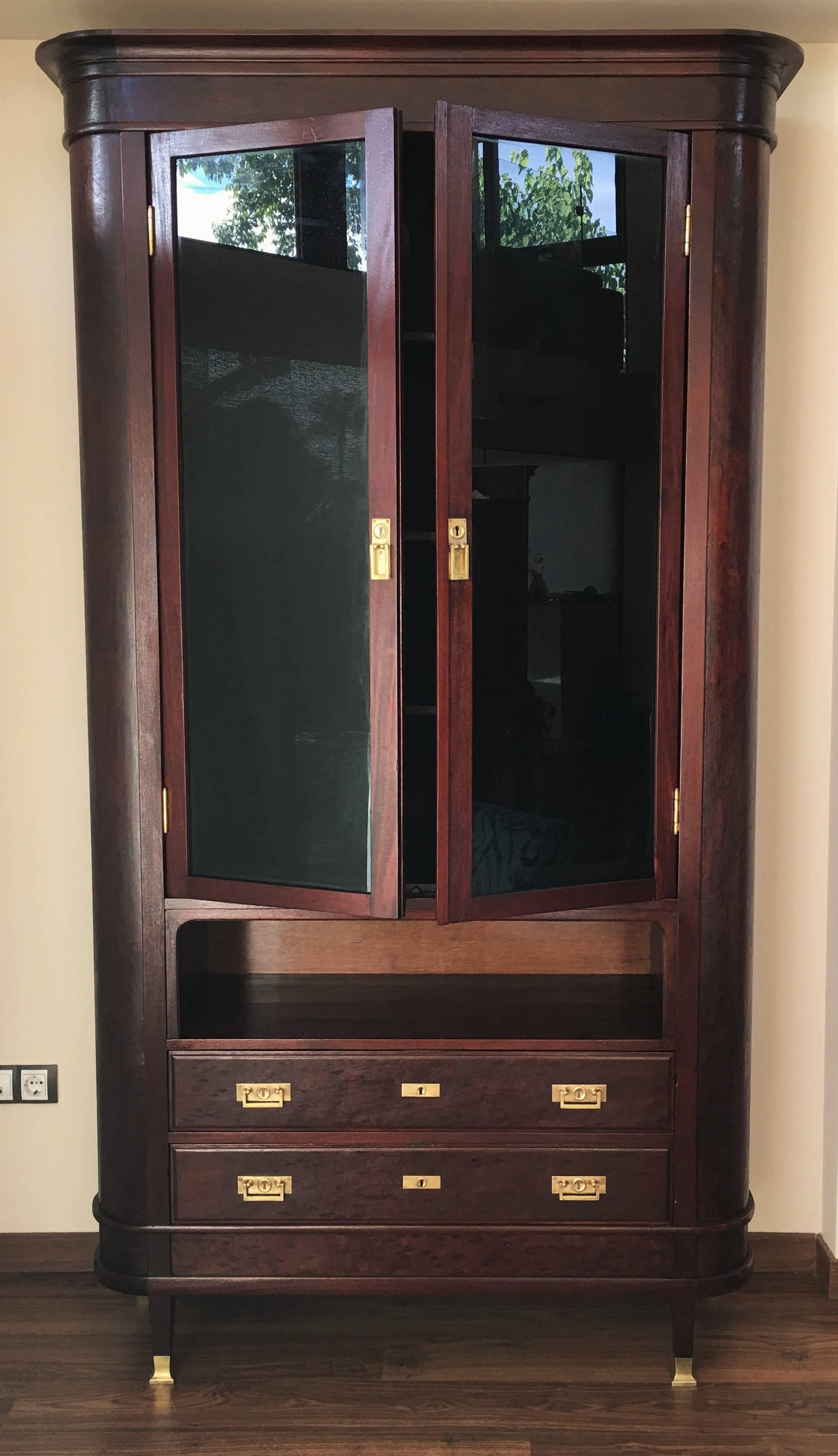 Mahogany Showcase Vitrine Art Decó with two drawers

Impressive mahogany bookcase from the 1920s. Upper section has two black glass-front doors with three shelves, perfect for housing and showcasing your books or collectables. Lower section has two