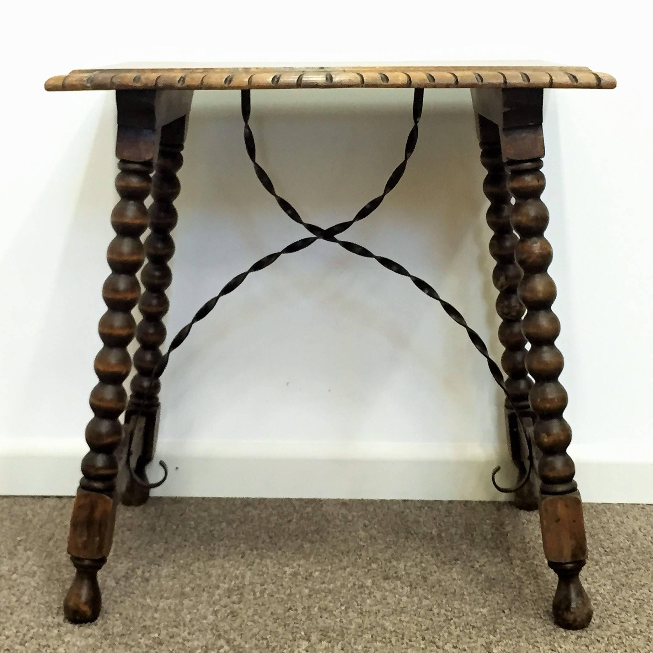 18th century Spanish side table.
Early 19th century Spanish trestle table in walnut and iron. This piece has a great scale, lovely turned legs and iron stretcher. The top is made from a single piece of wood. This table could be used as an end