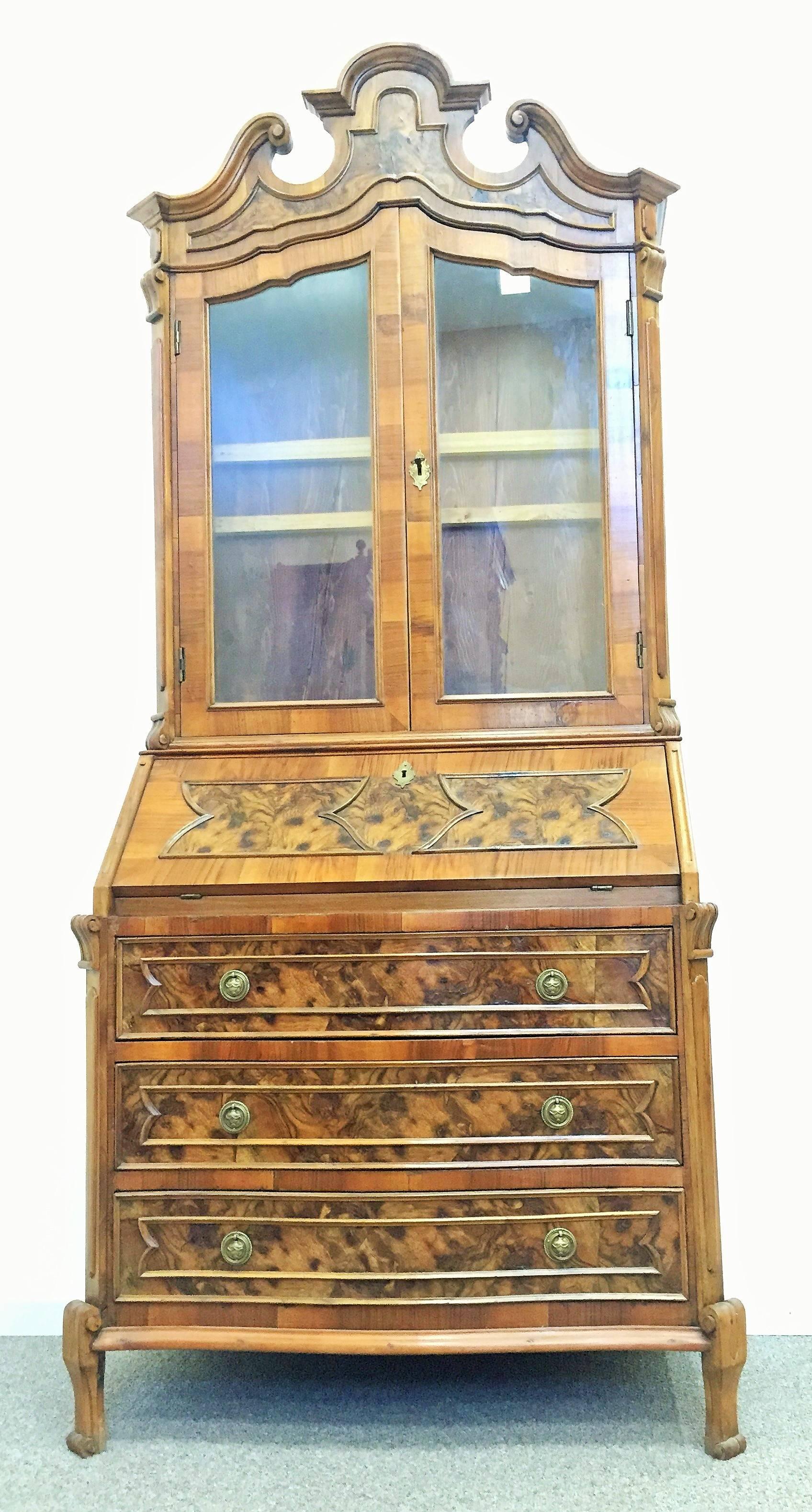 A late 18th century English George III mahogany Bureau bookcase ‘secretaire’ with fretwork open swan neck pediment, centred by a shaped finial, above a pair of glazed doors, slant front enclosed writing surface, fitted drawers and cubbies and below