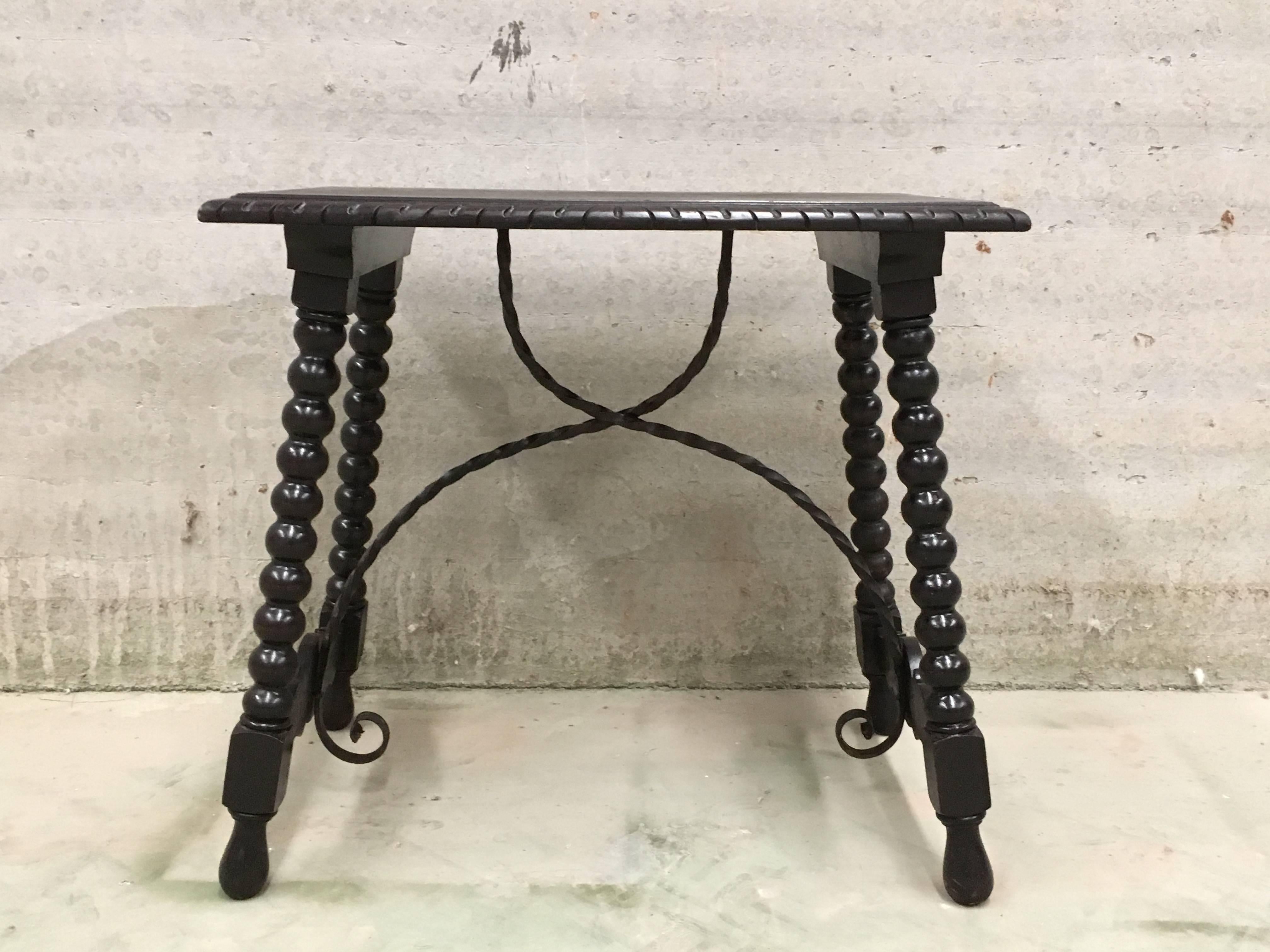 19th Spanish Baroque ebonized side table with iron stretcher and carved top in walnut.