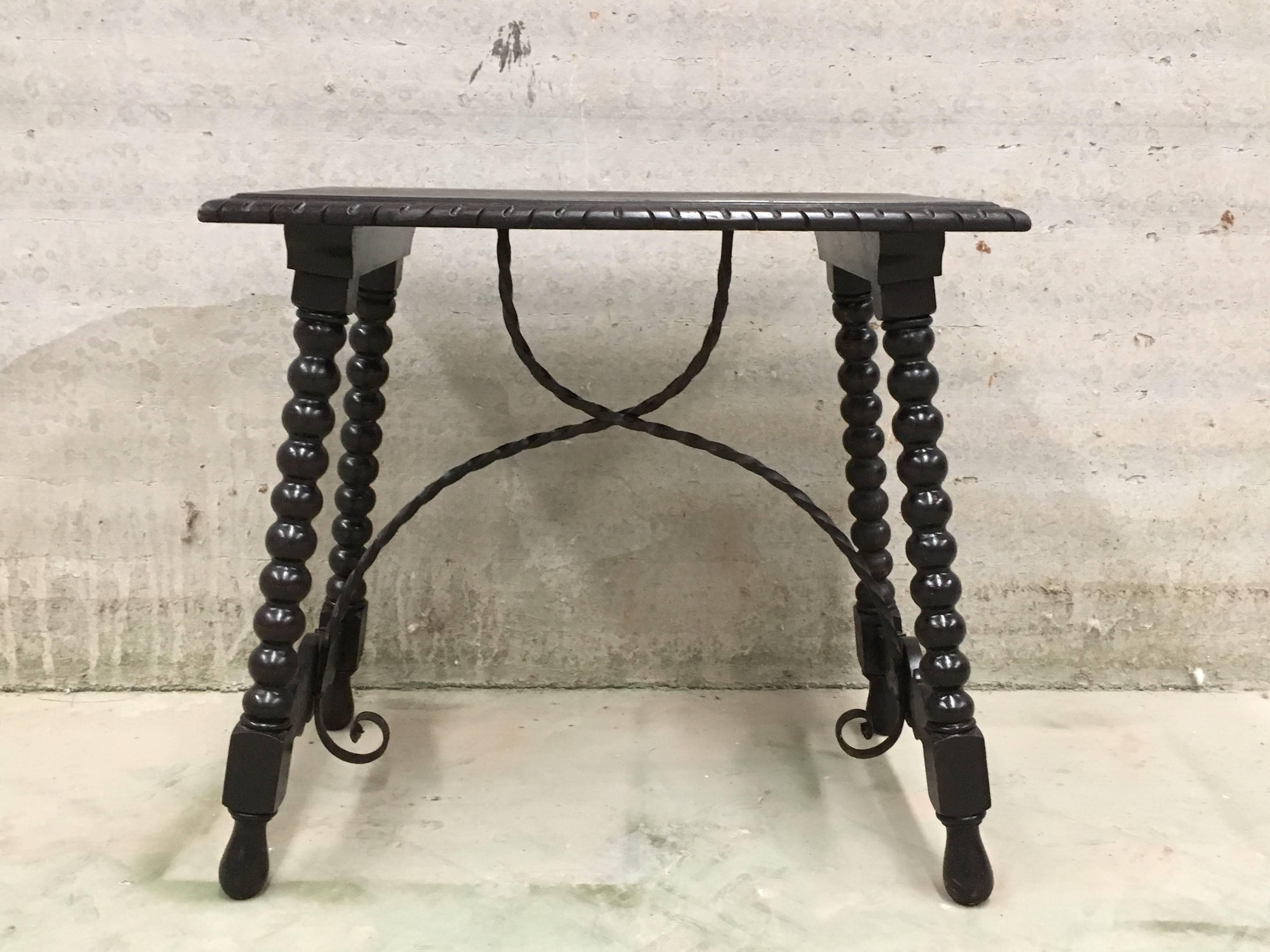 table d'appoint baroque espagnole du 19ème siècle en ébénisterie avec traverse en fer et plateau sculpté en noyer.