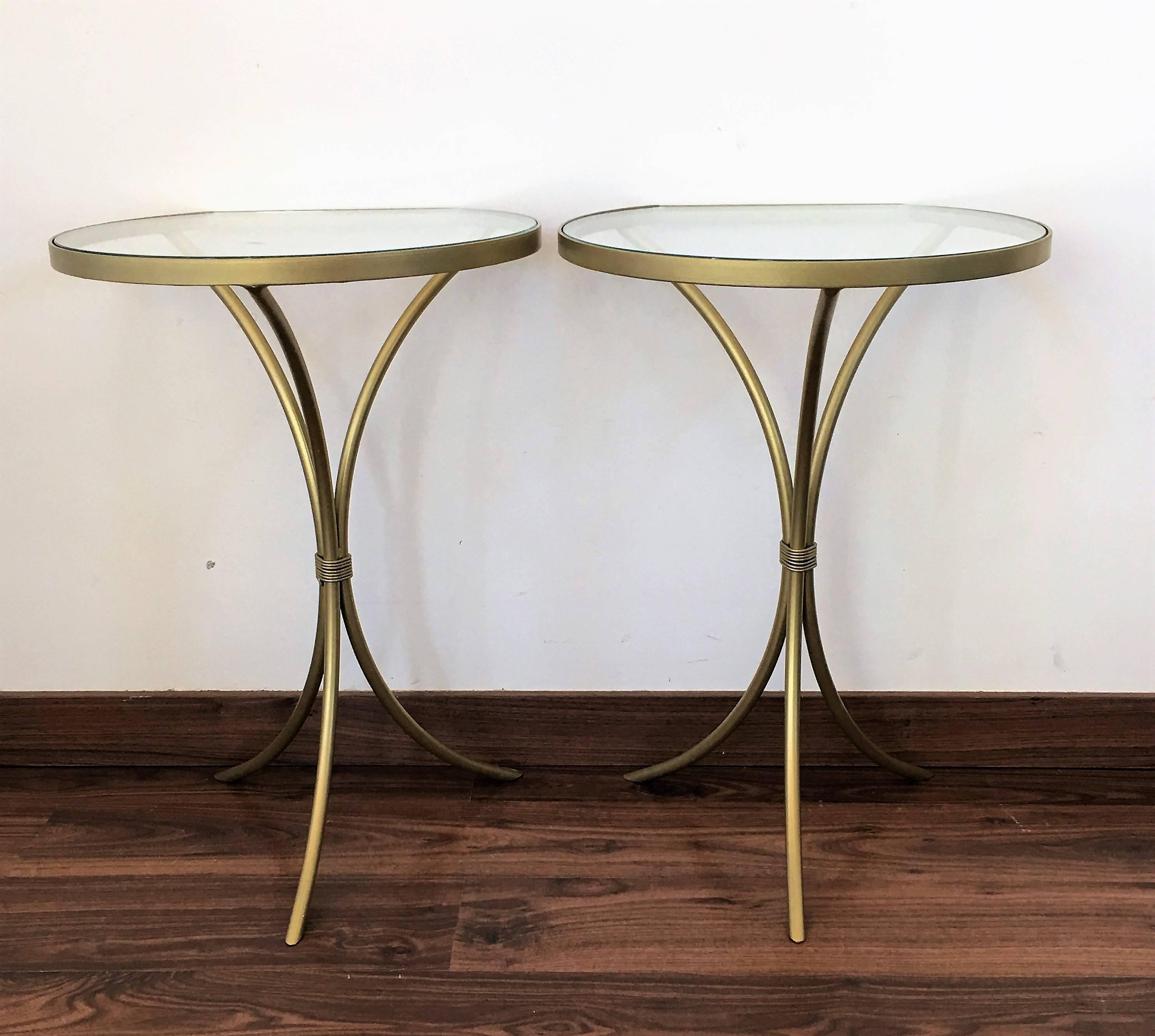 Pair of Italian midcentury glass and brass tripod side, end or nightstands
A pair of Italian midcentury hand blown Murano glass side or end tables with round glass tops embedded by large iron finials supported by gold fluted columns resting on gold