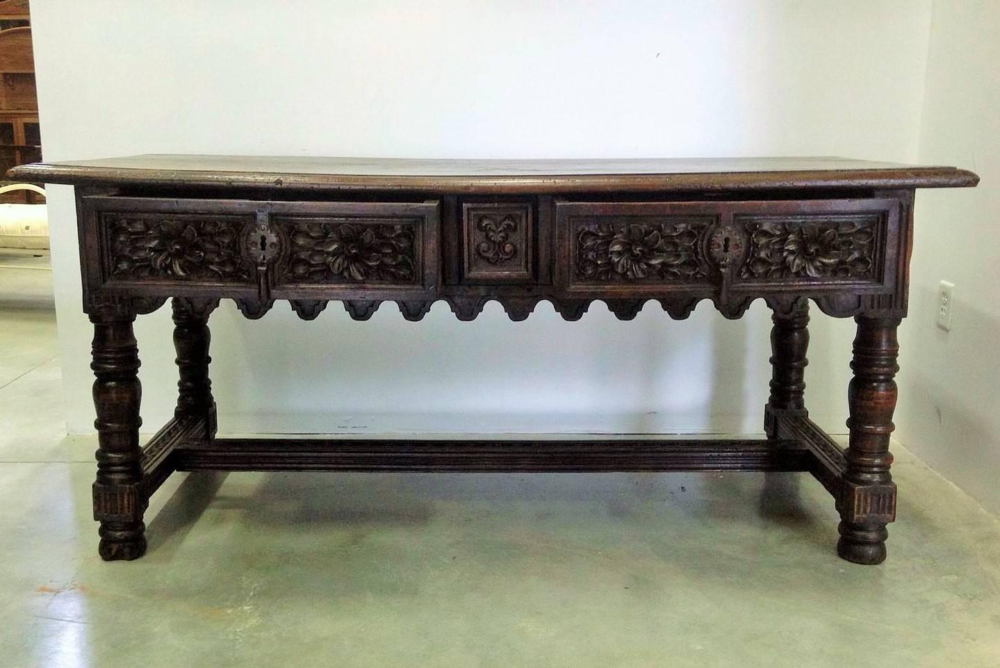 A Spanish Baroque walnut table. The rectangular top above two frieze drawers, over ring turned legs, joined by stretchers to the sides and one central stretcher on bun feat.
17th century Spanish refectory console table.

 