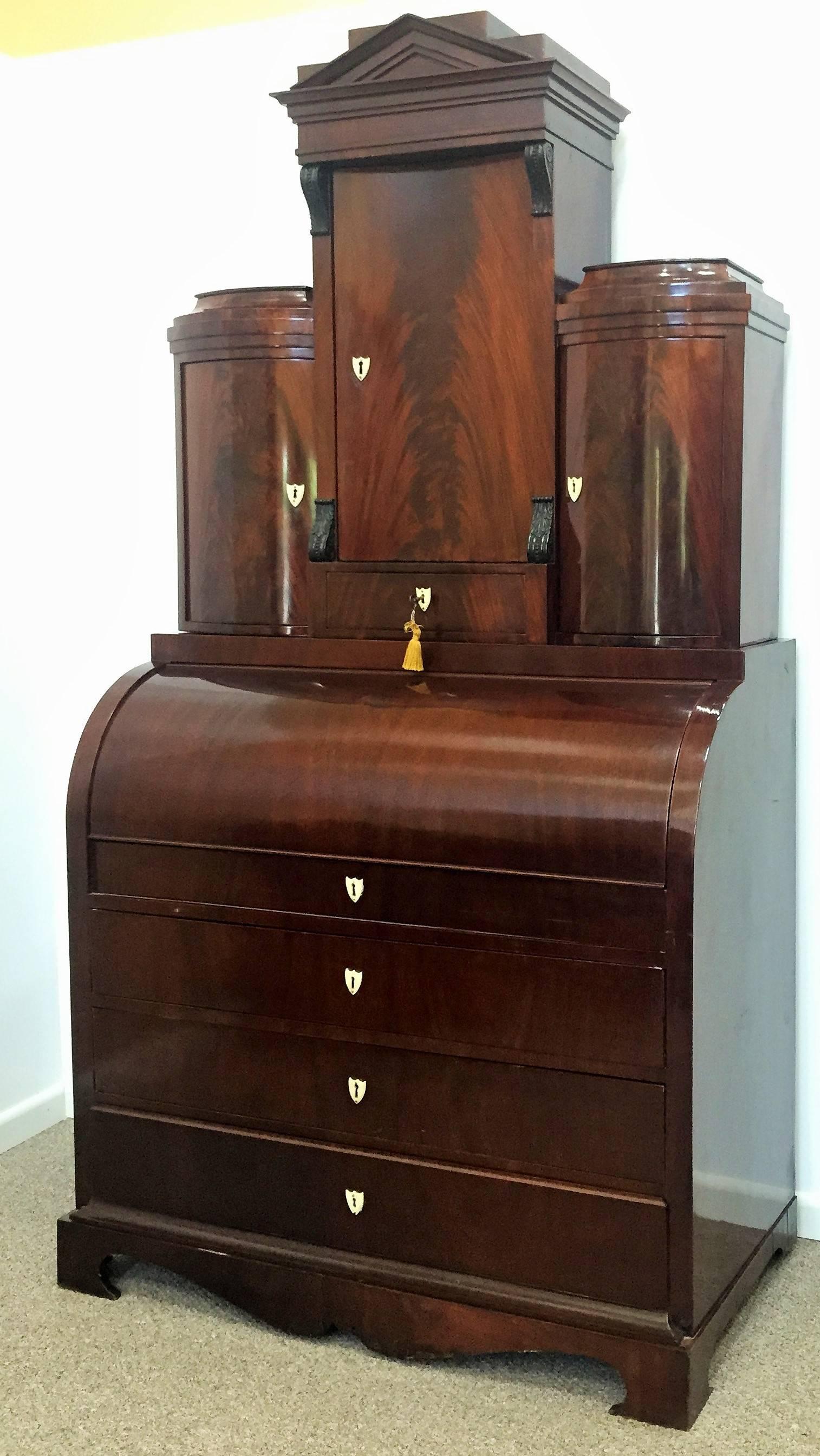 A very fine Empire secretary in West Indies mahogany, also known as Cuban mahogany, considered to be among the finest mahoganies because of its beautiful grain and color, Denmark, circa 1820.

Cylinder top opens to a pull-out desk which offers an
