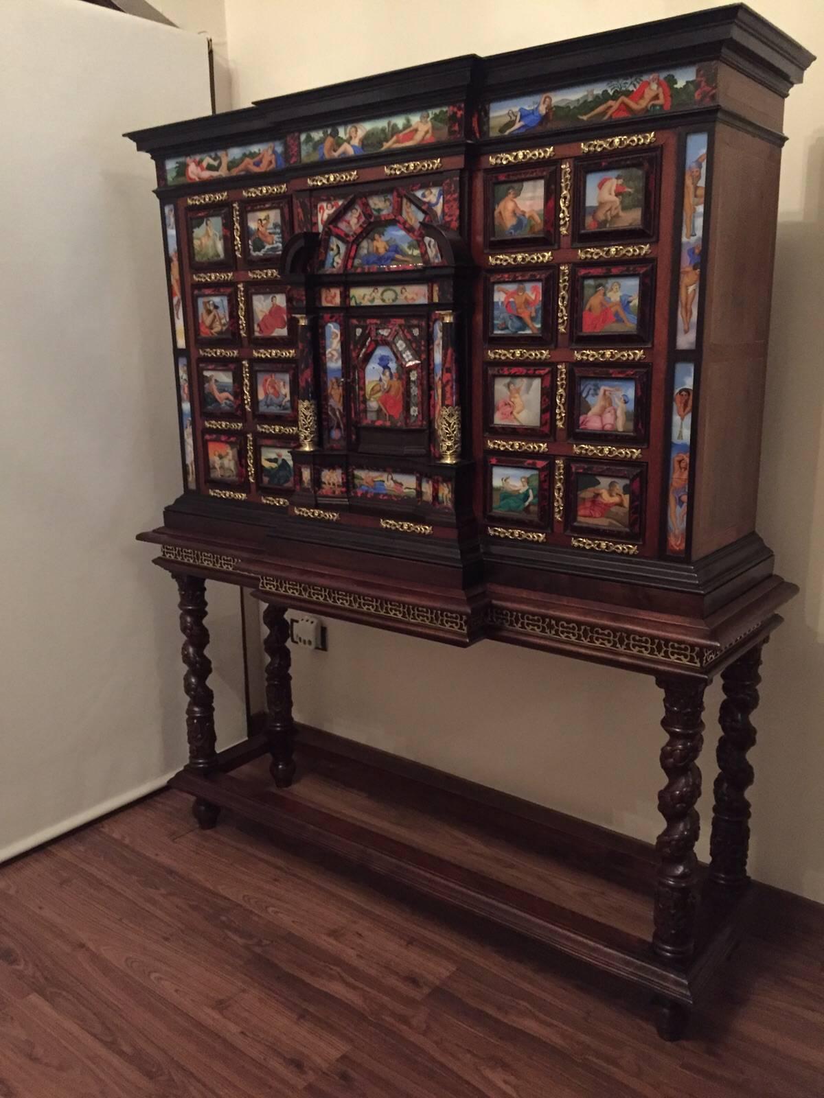 Important monumental cabinet on stand.
The case of the cabinet is walnut, veneered with rich rib boned ebony and luxuriously decorated with turtle shell, bronze, carey.
Bargueno with 49 glass paintings in bright colors, depicting gods of