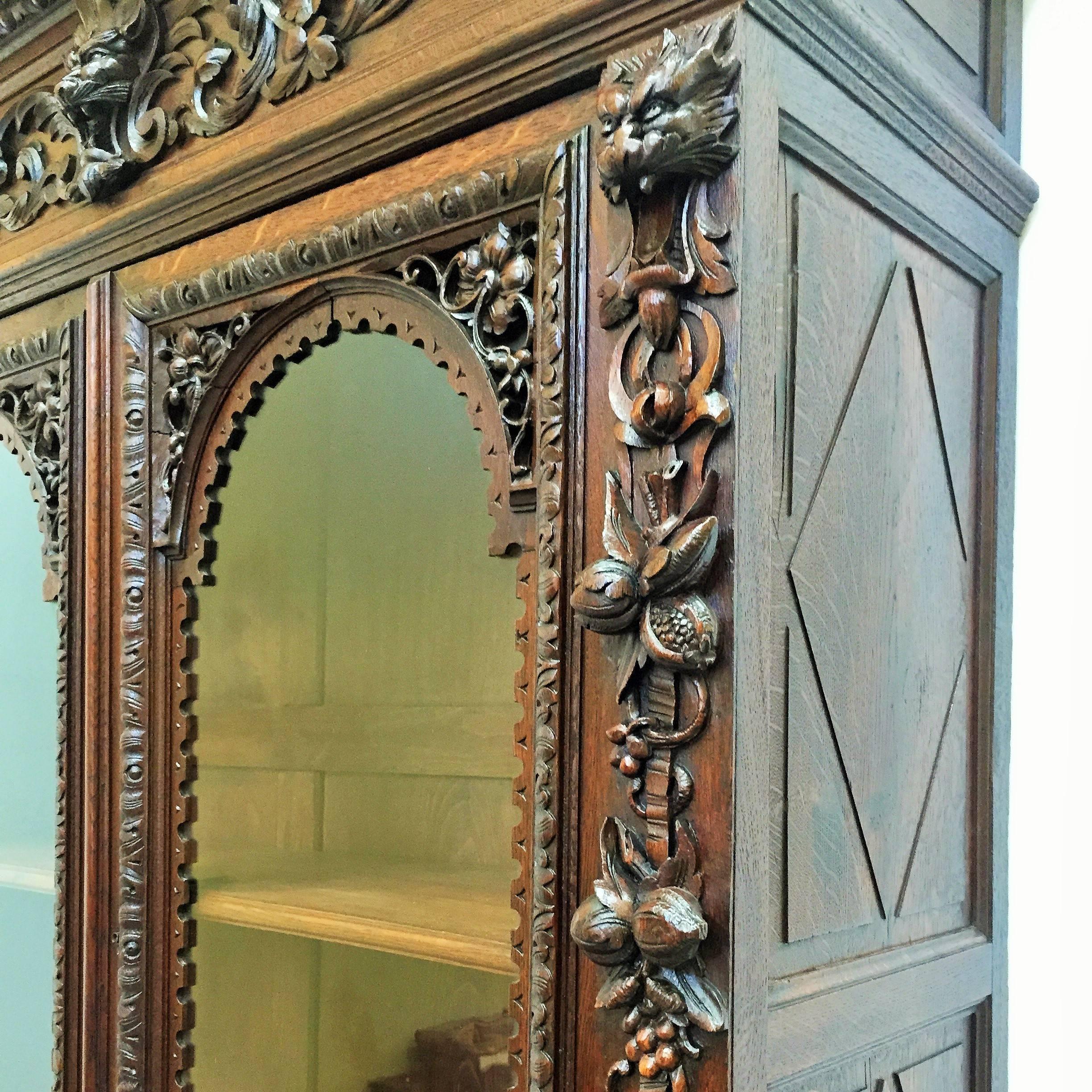Buffet flamand à deux corps en chêne, exceptionnellement bien sculpté, dans le style néo-renaissance d'Henri II. Cette armoire présente des sculptures très bien articulées en haut-relief de grenades, raisins, vignes, feuilles d'acanthe, guirlandes