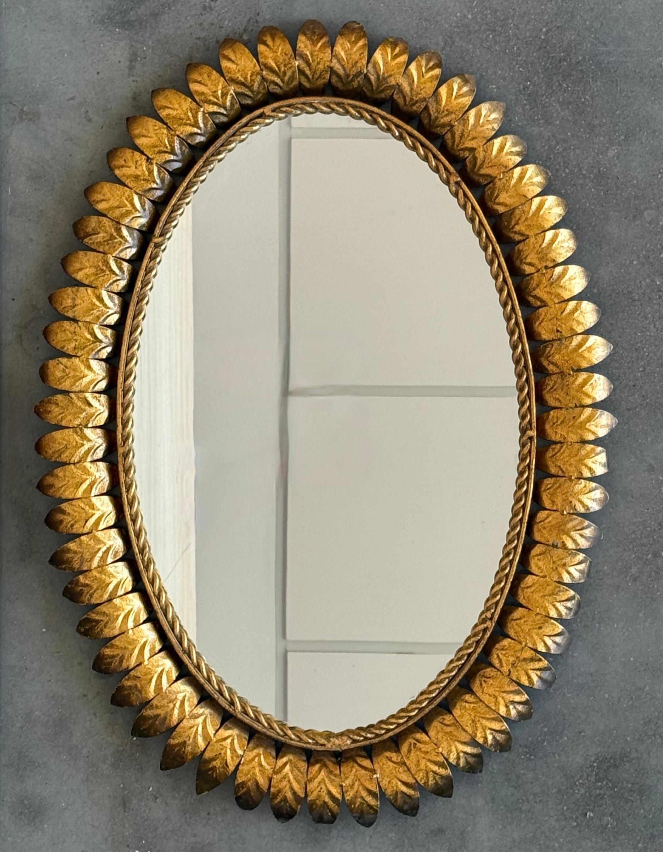 Specchio ovale spagnolo degli anni '50 in metallo dorato con cornice a foglia stretta.


