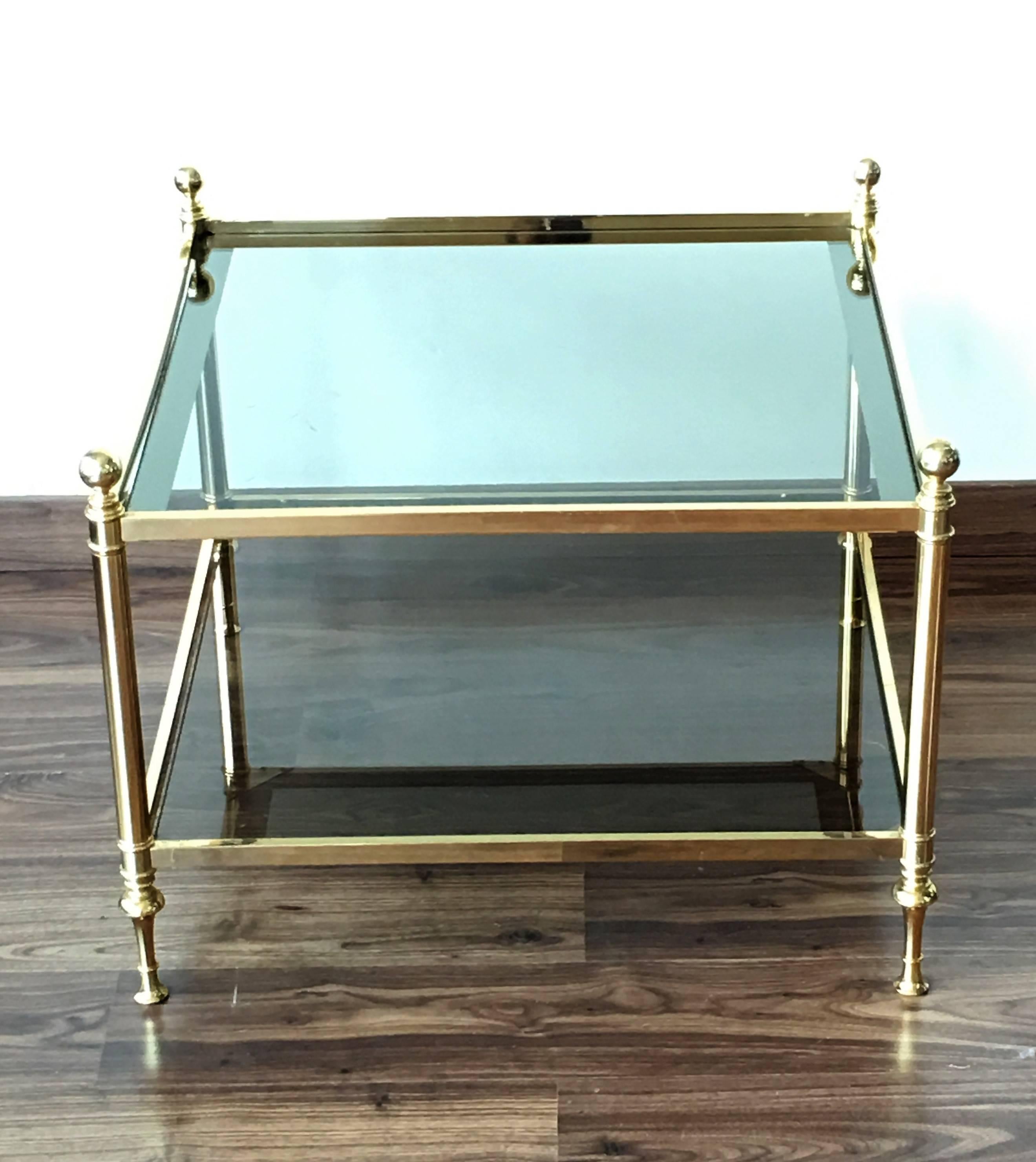 French vintage square coffee table in solid gilt brass with two glass shelves and ball finials. Iconic Maison Baguès piece with great proportions