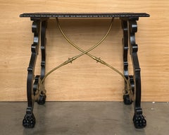 Mesa de centro antigua de madera tallada ebonizada con travesaños de latón y patas en forma de garra