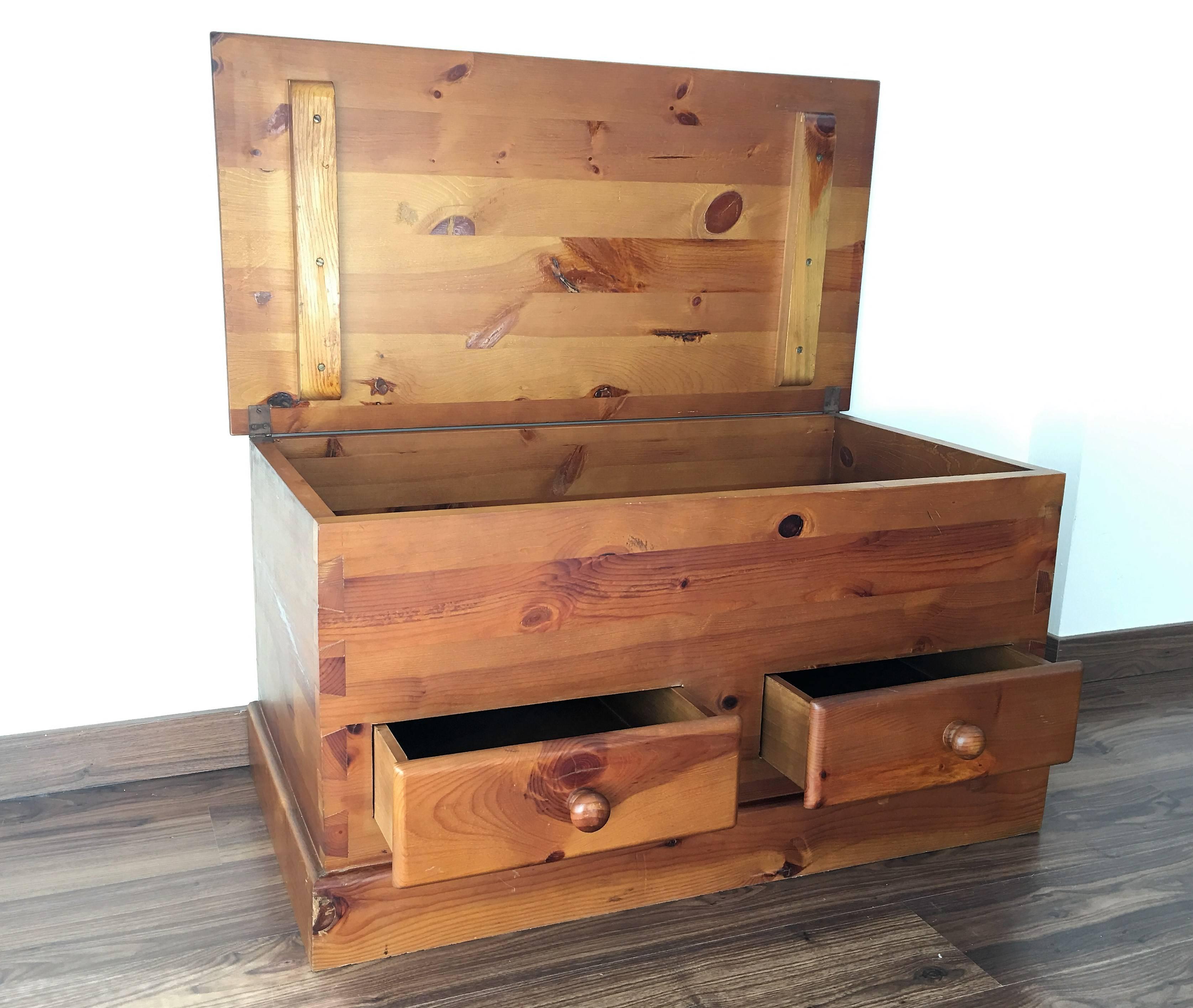20th century chest on bracket feet with a top that opens to reveal storage and drawers below.