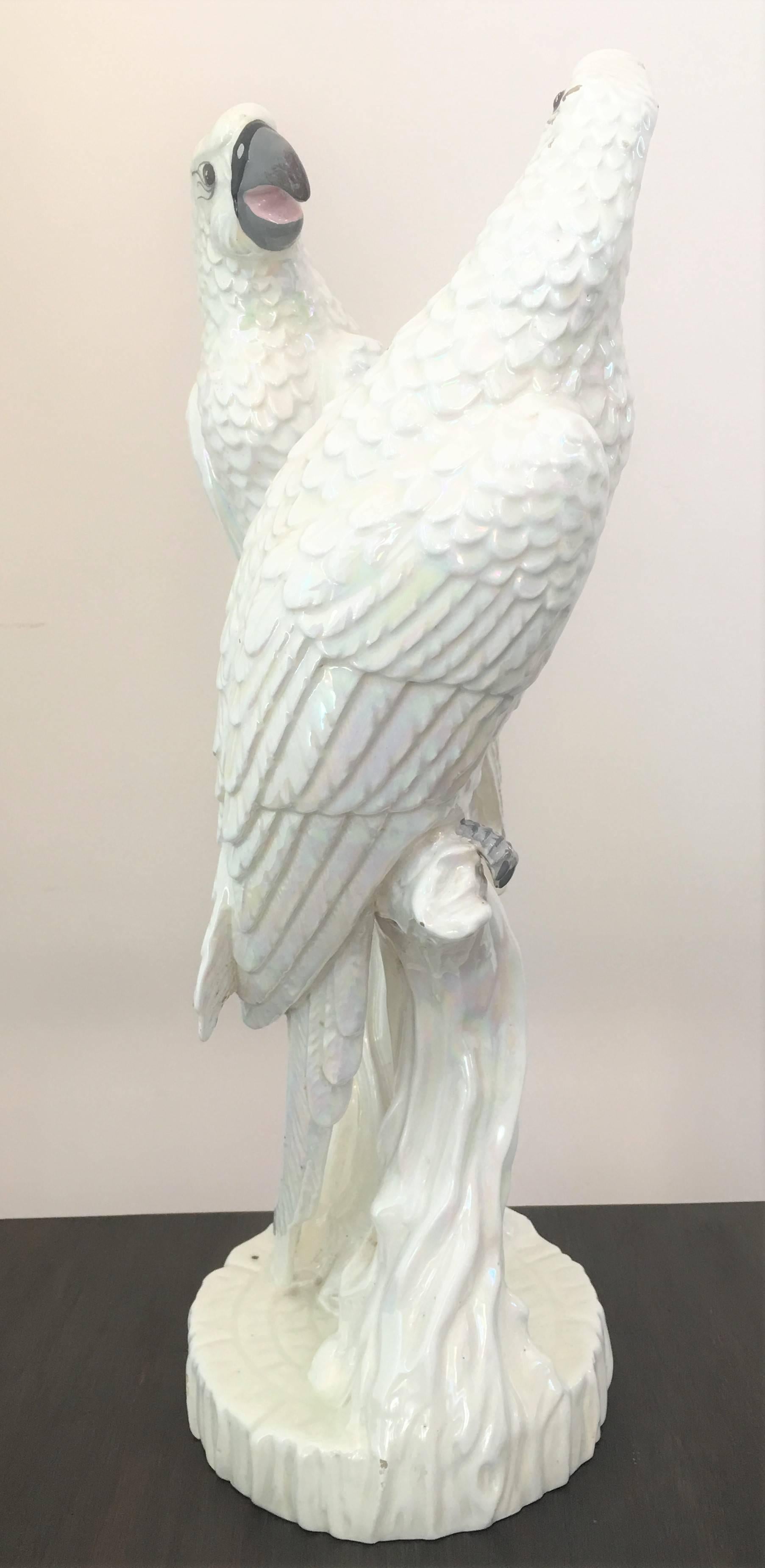 Large Mid-Century ceramic parrots with a white iridescent glaze, both perched on trunk with opposing postures. 

 
