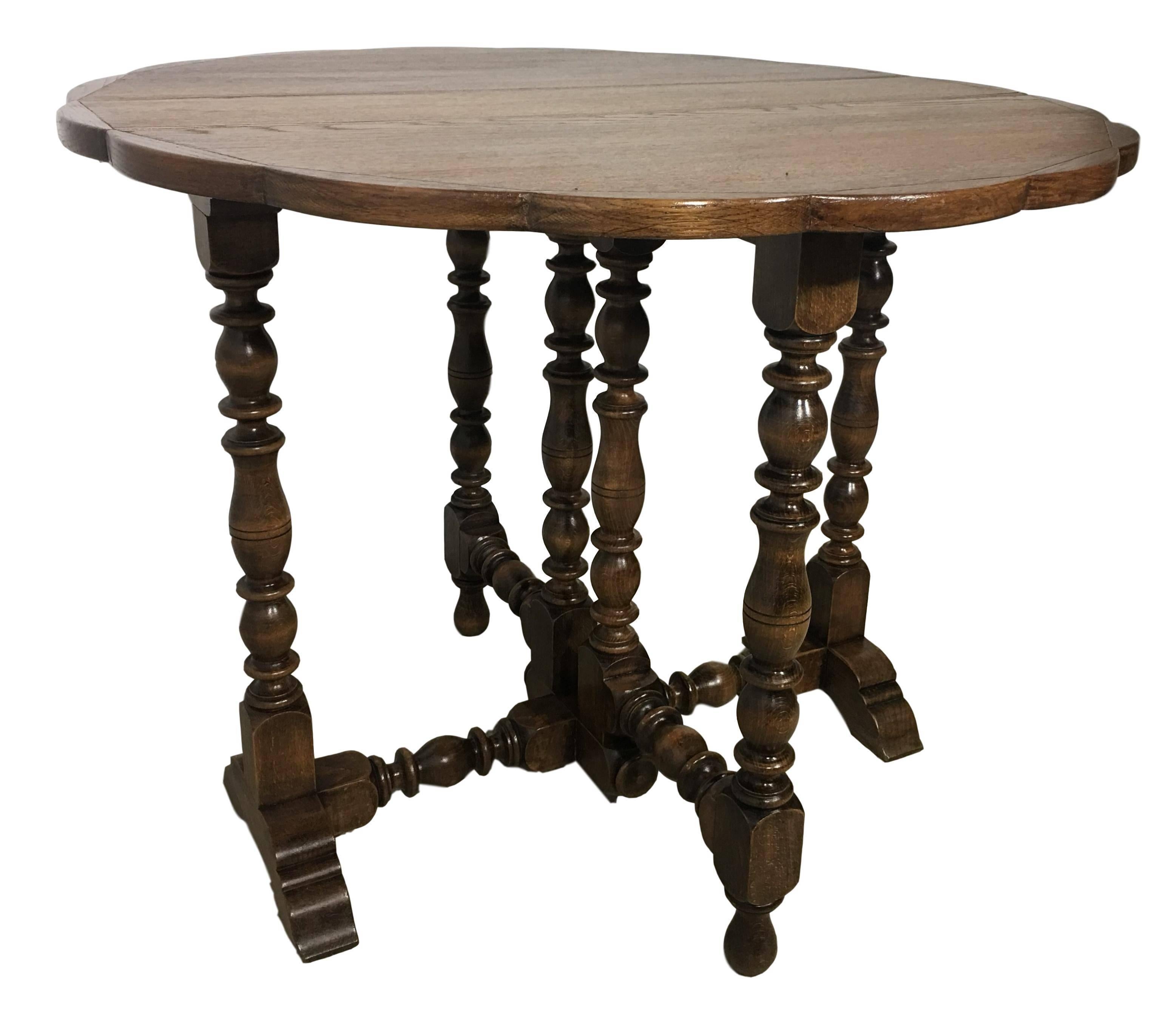 English oak gateleg table with a beveled edge around the top following down to a simple apron and hand-turned barley twist legs, joined by simple stretchers and raised on turned feet, circa 1900. 
The top open measures 36.61 x 19.25in.

 