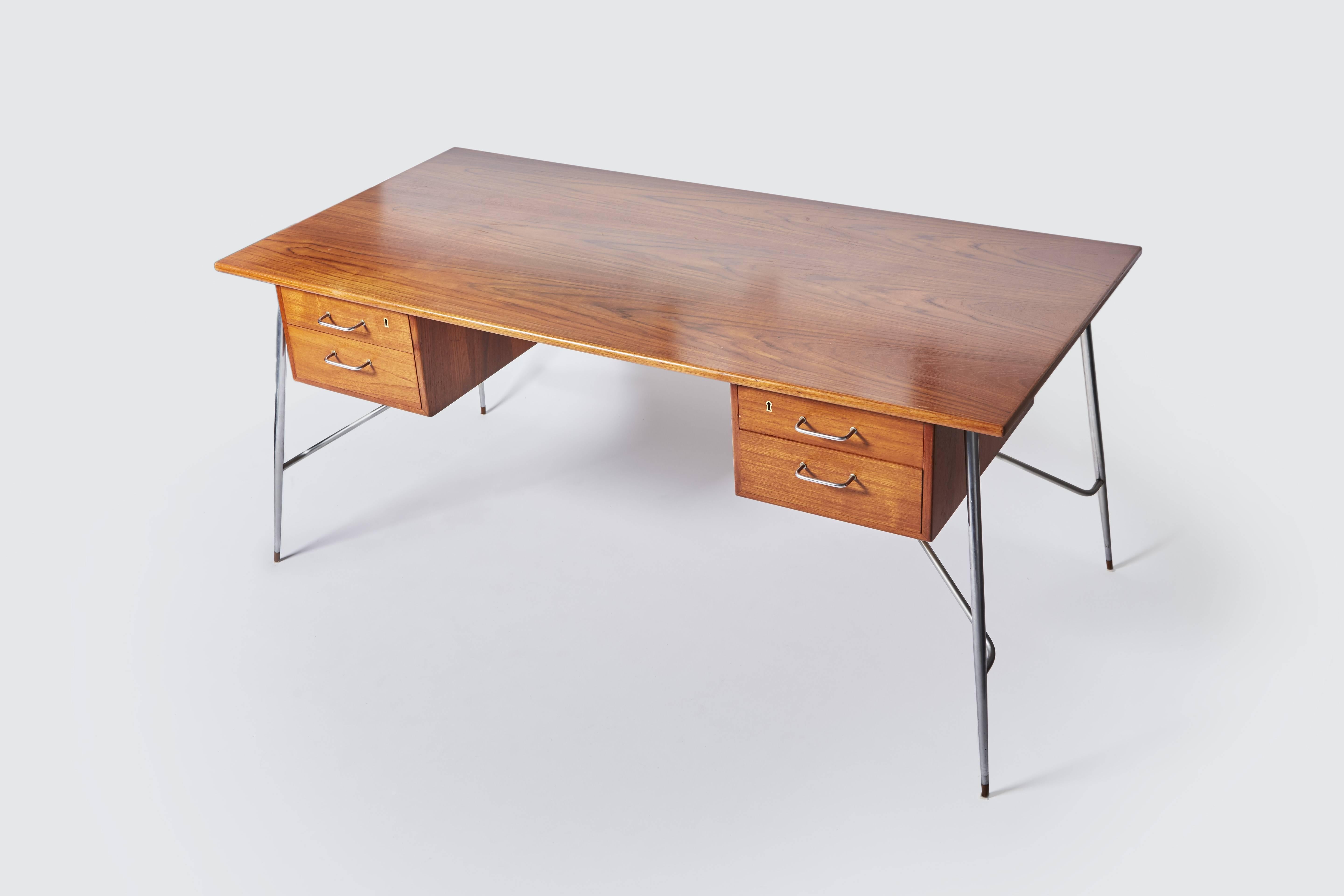 Large four-drawer desk. Teak top and steel leg structure. The two upper drawers are decorated with keyholes.

Desk “202”, Danish work by designer Børge Mogensen, edited by Soborg Mobelfabrik, circa 1953.