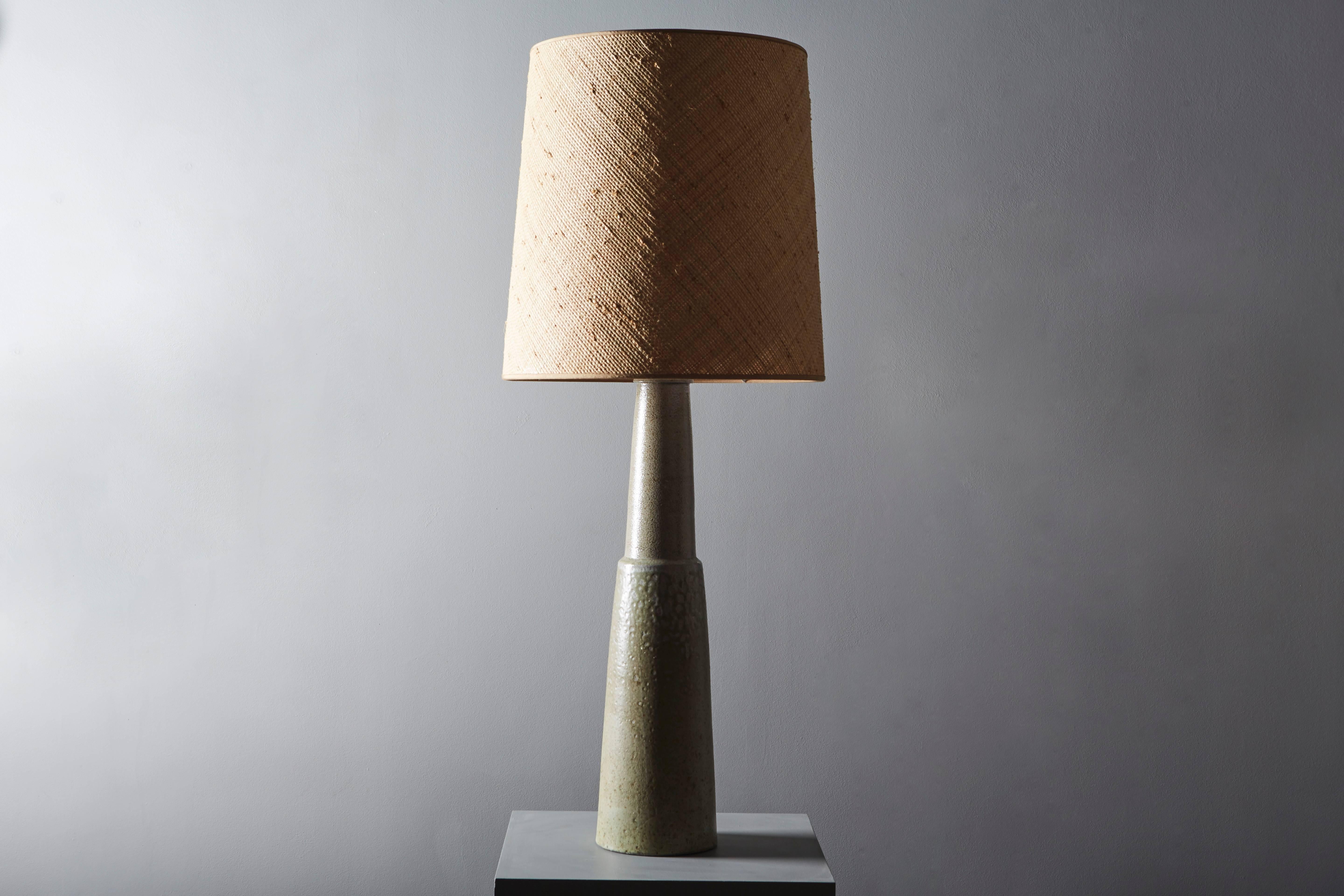 Enameled sandstone lamp, in natural colors, with texture effects. The base is truncated-cone shaped.

The shade is new, made by Maison Capeline, Paris.

Danish work by Kähler, circa 1950.

Measures: Lamp base only is 23.6 in high and 6.7 in