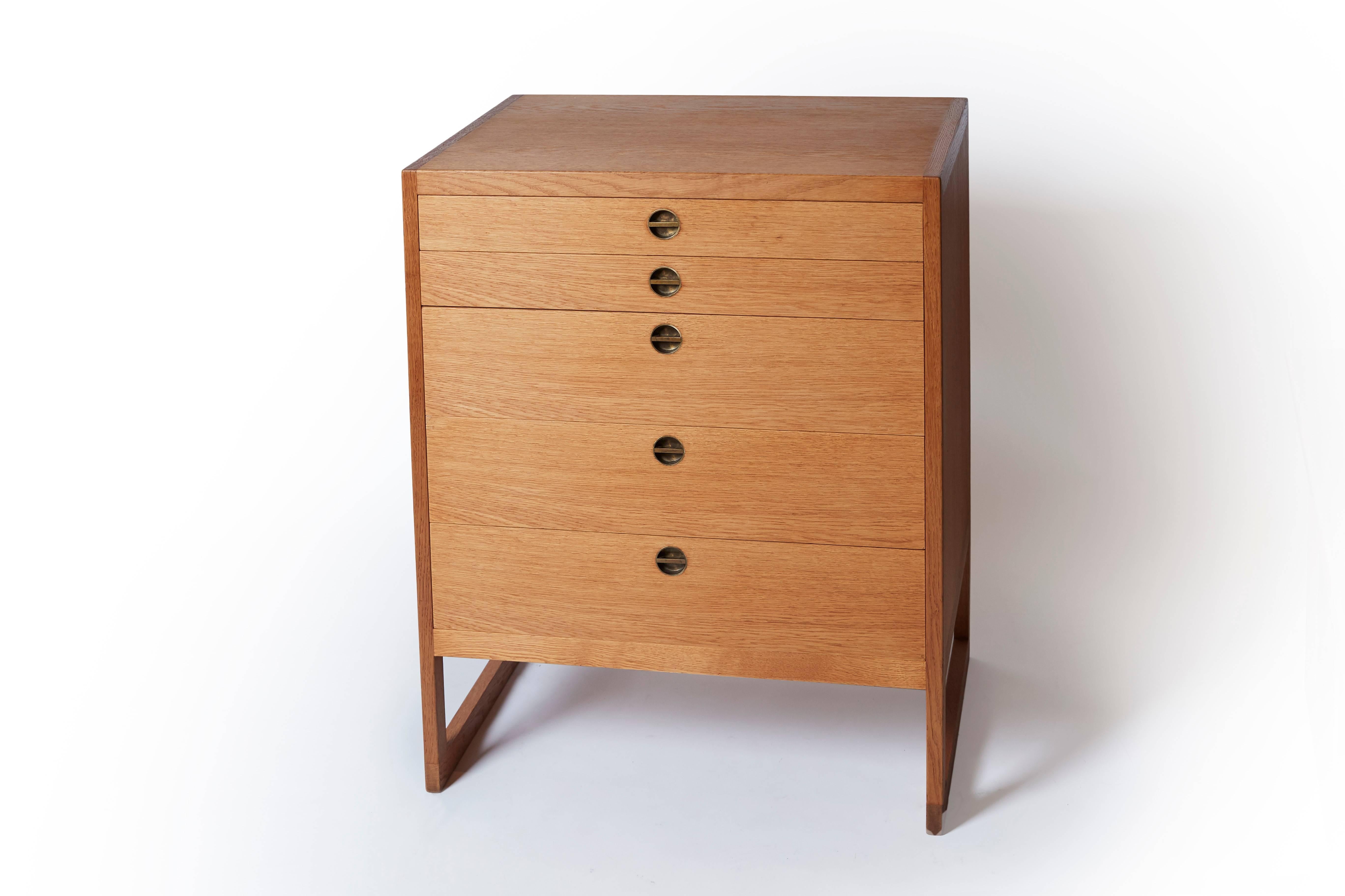 A five-drawer cabinet in oak, decorated with circular brass handles. Model BM 59, edited by P. Lauritzen & Sons.
Danish work by designer Borge Mogensen, circa 1957.