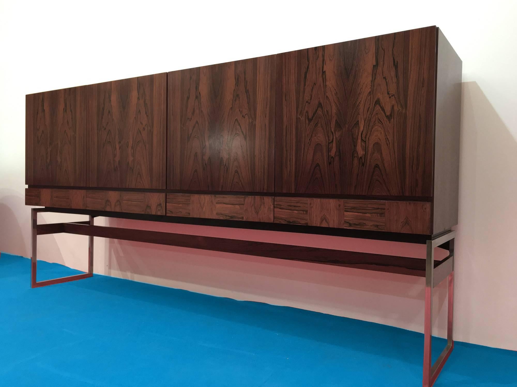 Elegant Rudolf Bernd Glatzel Rio rosewood dressoir, sideboard for Fristho Franeker in Netherlands. It's opening with four doors and four drawers. The maple inlay shelves and drawers provide a large storage space. The metal chromed base is orned with
