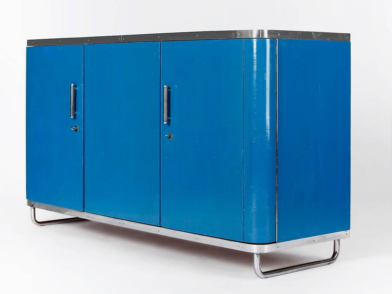 This tubular steel sideboard was made in Czechoslovakia in the 1930s
and is blue laquered.
It has been cleaned but remained in the good and not restored condition.
The chromed tubular steel has a nice patina.