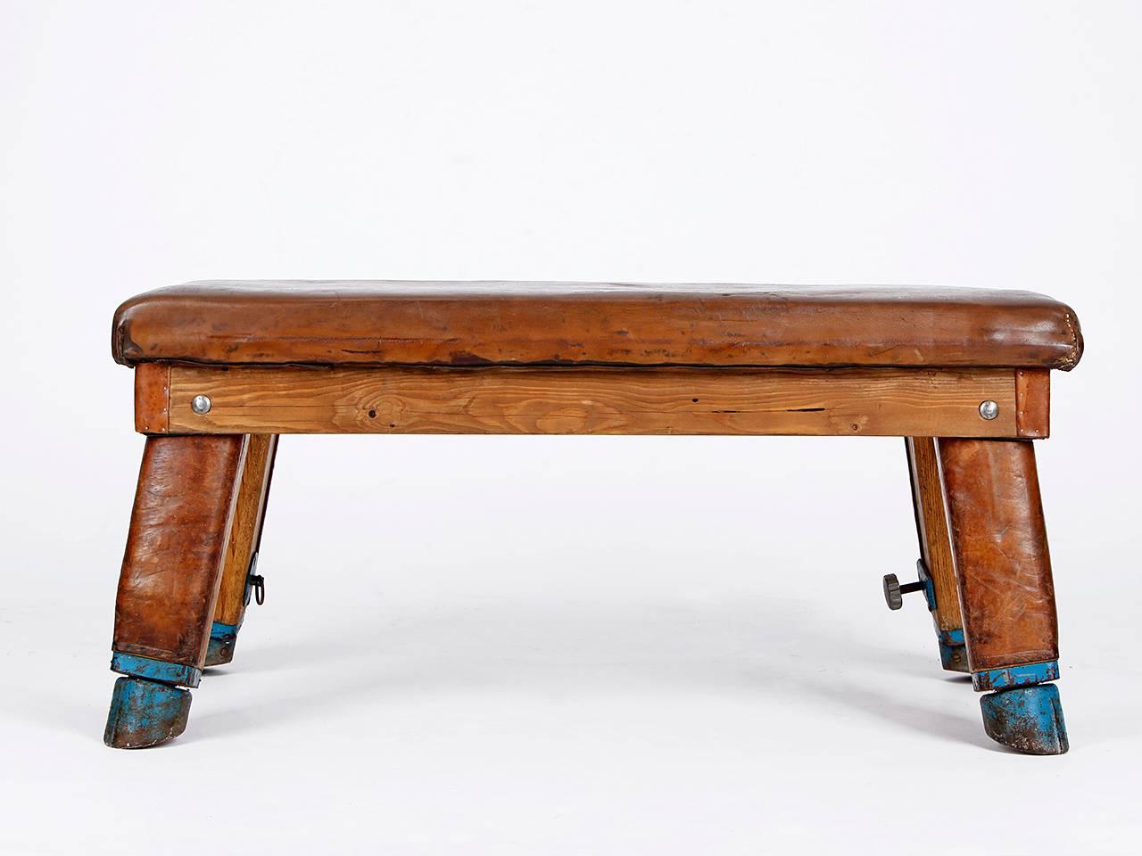 This gym bench was made in the 1930s in former Czechoslovakia.
The top is padded with thick cowhide leather, the splayed legs,
have metal cuffs. Very nice patina, very nice vintage condition.
 