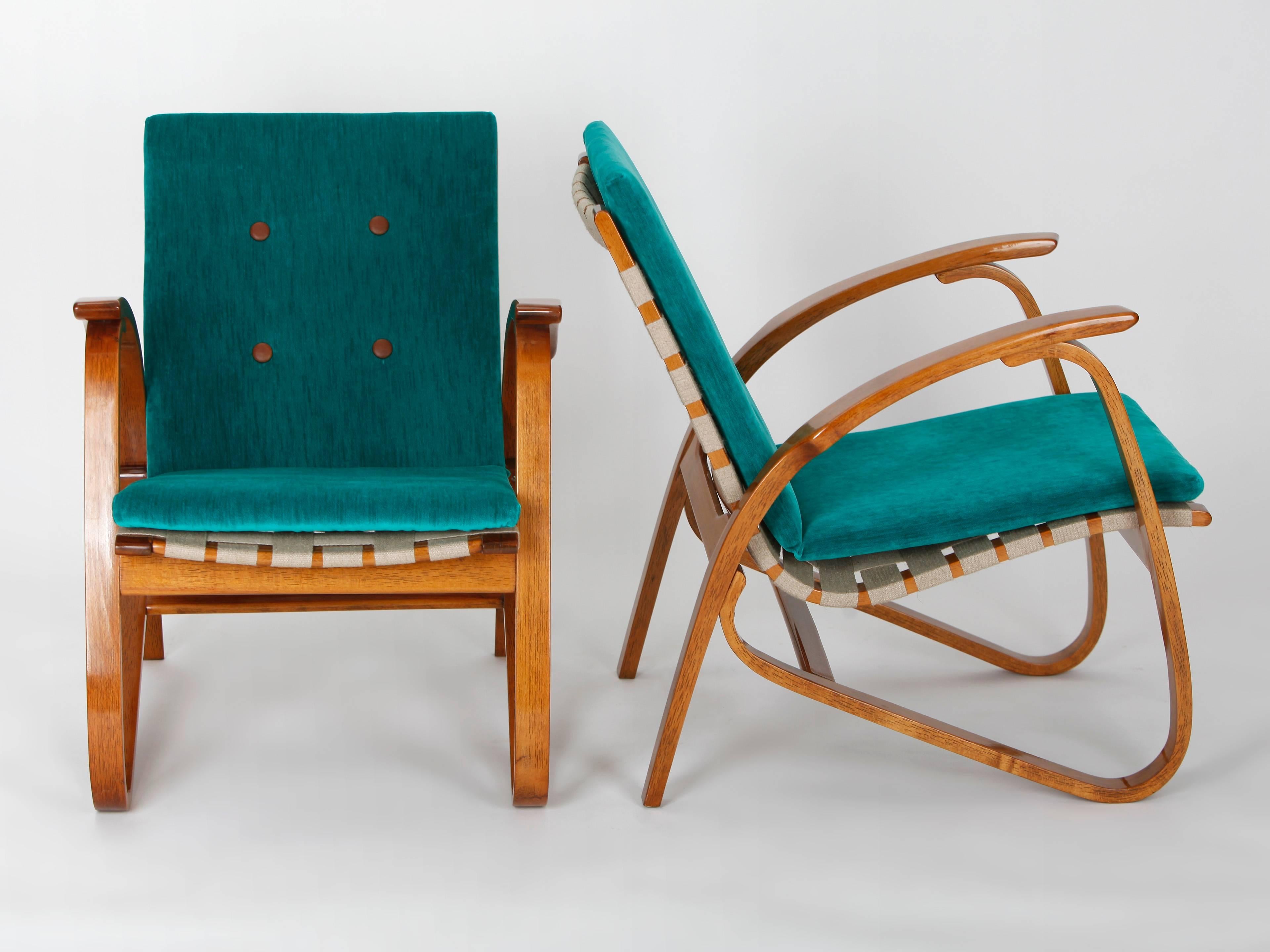 These two armchairs were designed by Jan Vanek in the 1930s. The hemp straps have been renewed and the wooden parts have been relacquered. The cushions have a core of pressed coconut fibers. The chairs have been upholstered with an English velvet