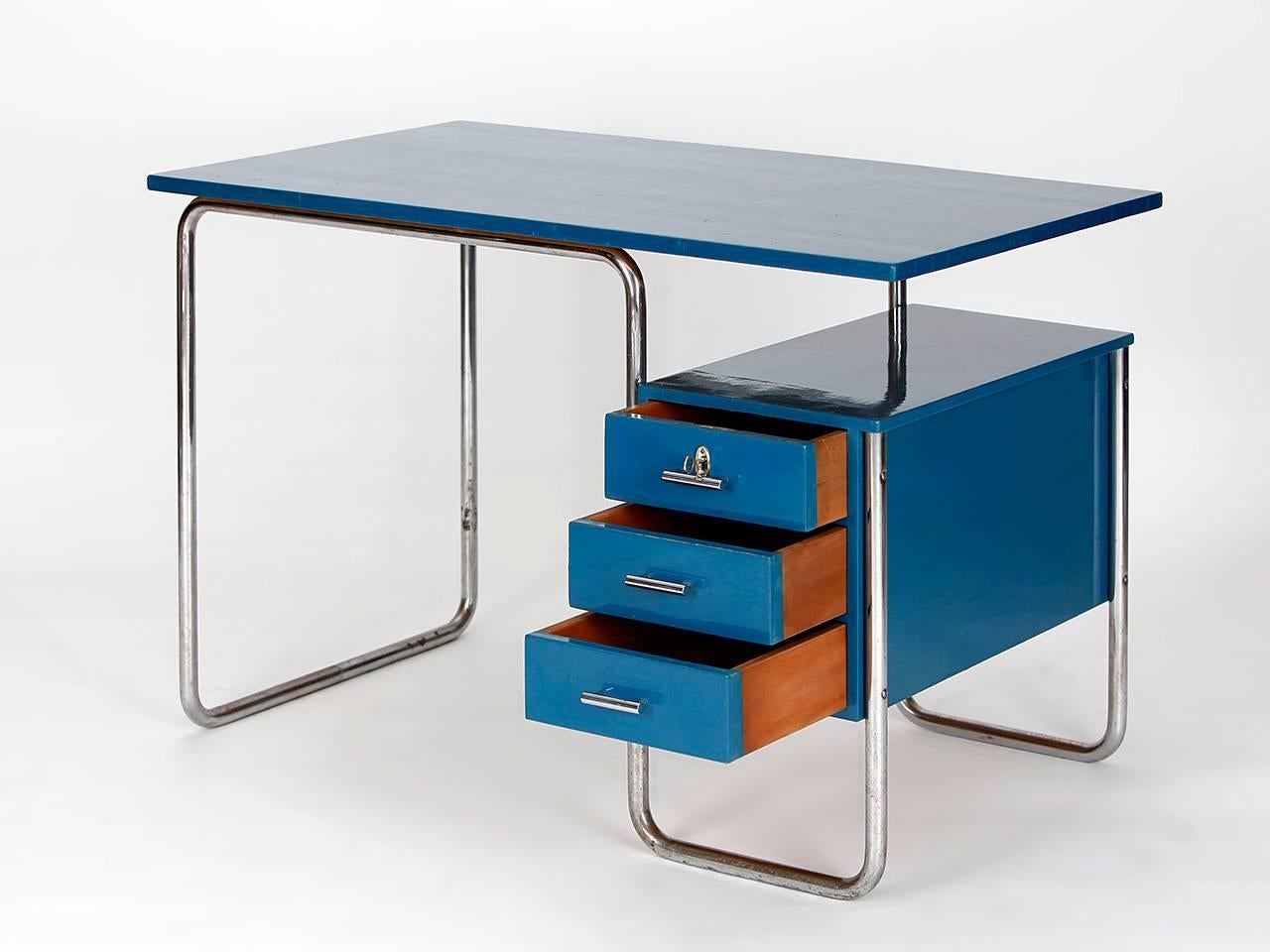 This office furniture set consists of a desk with a cantilever chair, a paper basket, and an étagère for filing. The original lacquer has been cleaned and restored. The chrome-plated tubular steel has a patina. The set was produced during the 1930s