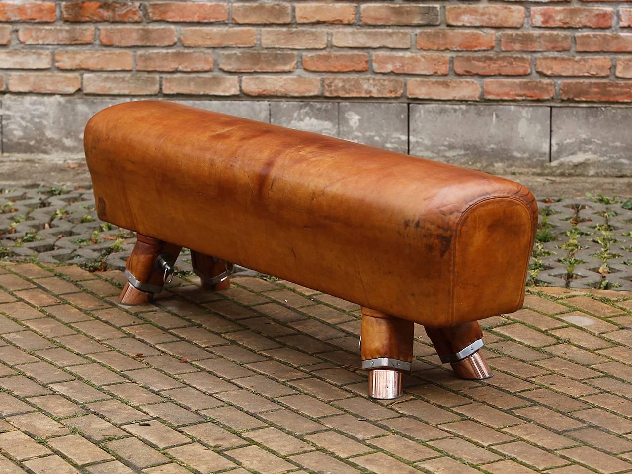 Made in the 1930s in the Czech Republic. Shortened to a seat height of 54cm. Thick cowhide with patina. Fancy and rare copper feet. This pommel horse never had grab handles, so the holes are missing on the top, see photo. Very good restored