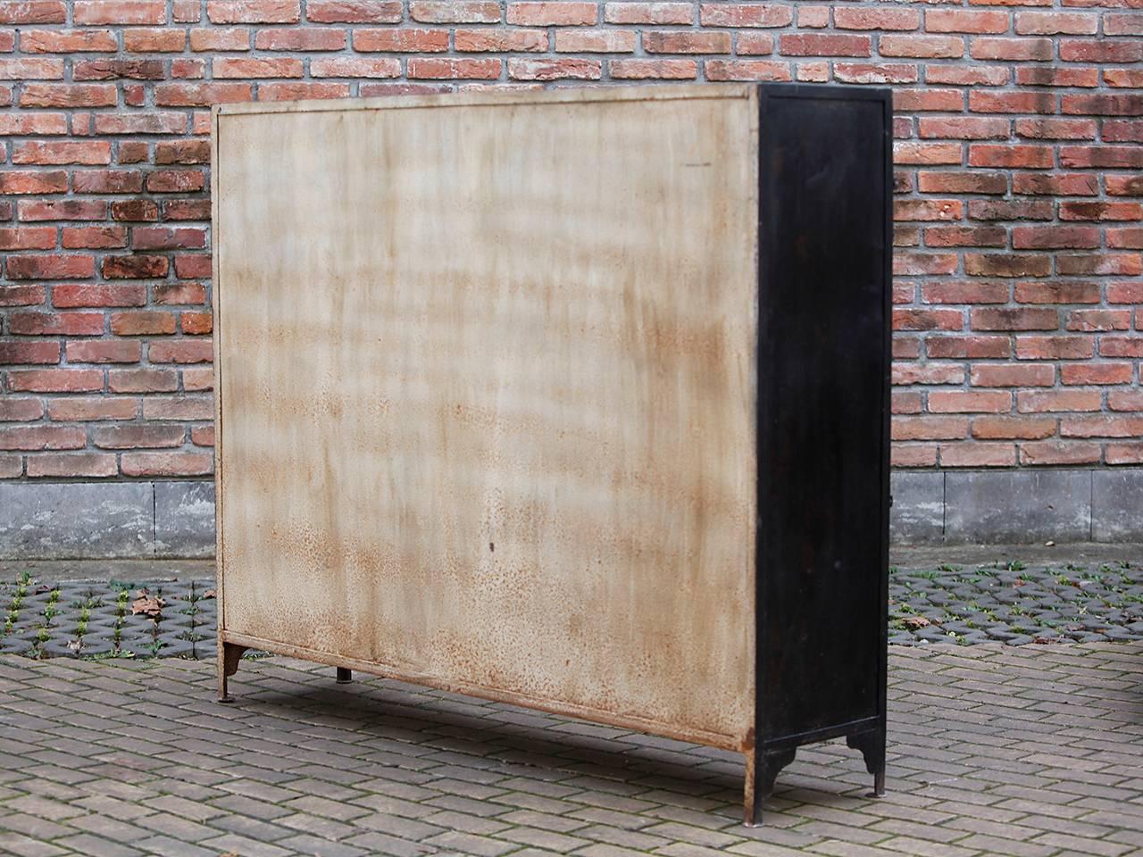 Made in the Czech Republic in the 1930s. Heavy iron construction with doors and shelves
The doors are numbered. The cabinet has been cleaned and is in original condition.

 