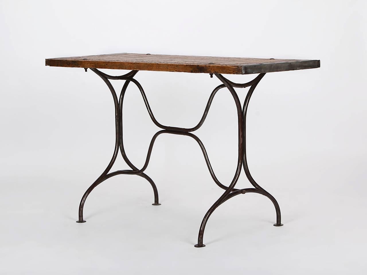 This table was made in the former Czechoslovakia, and features a curved iron frame, and a wooden tabletop. Partially restored, iron frame has slight signs of wear, wooden tabletop restored and waterproofed.
 