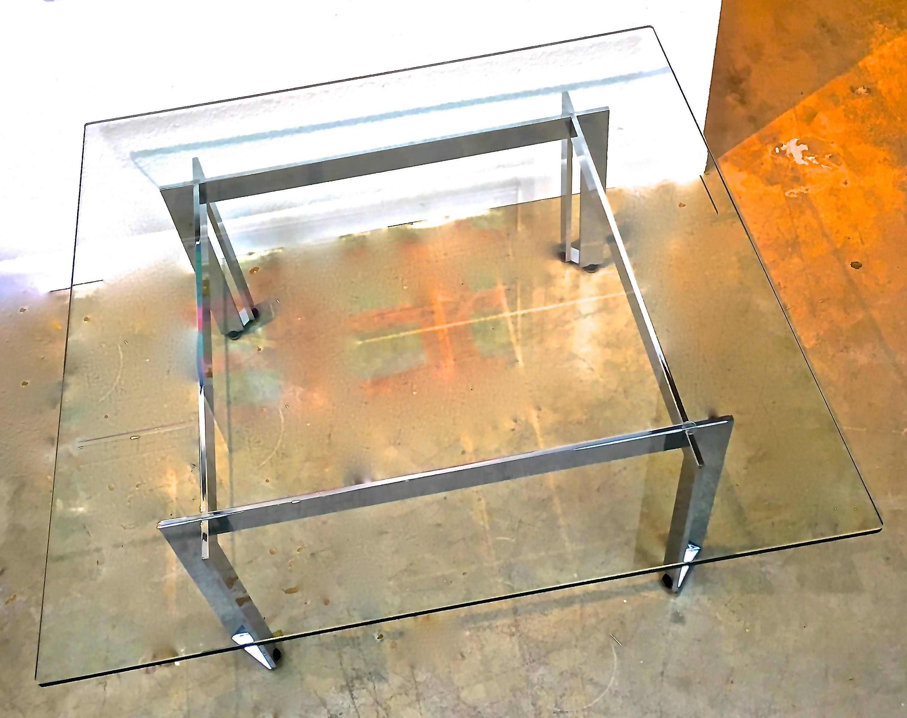 The intersecting chrome corner beams create unique angled legs that differentiate this table from the more ubiquitous Mid-Century table design. Architectural and substantial it supports a 1/2