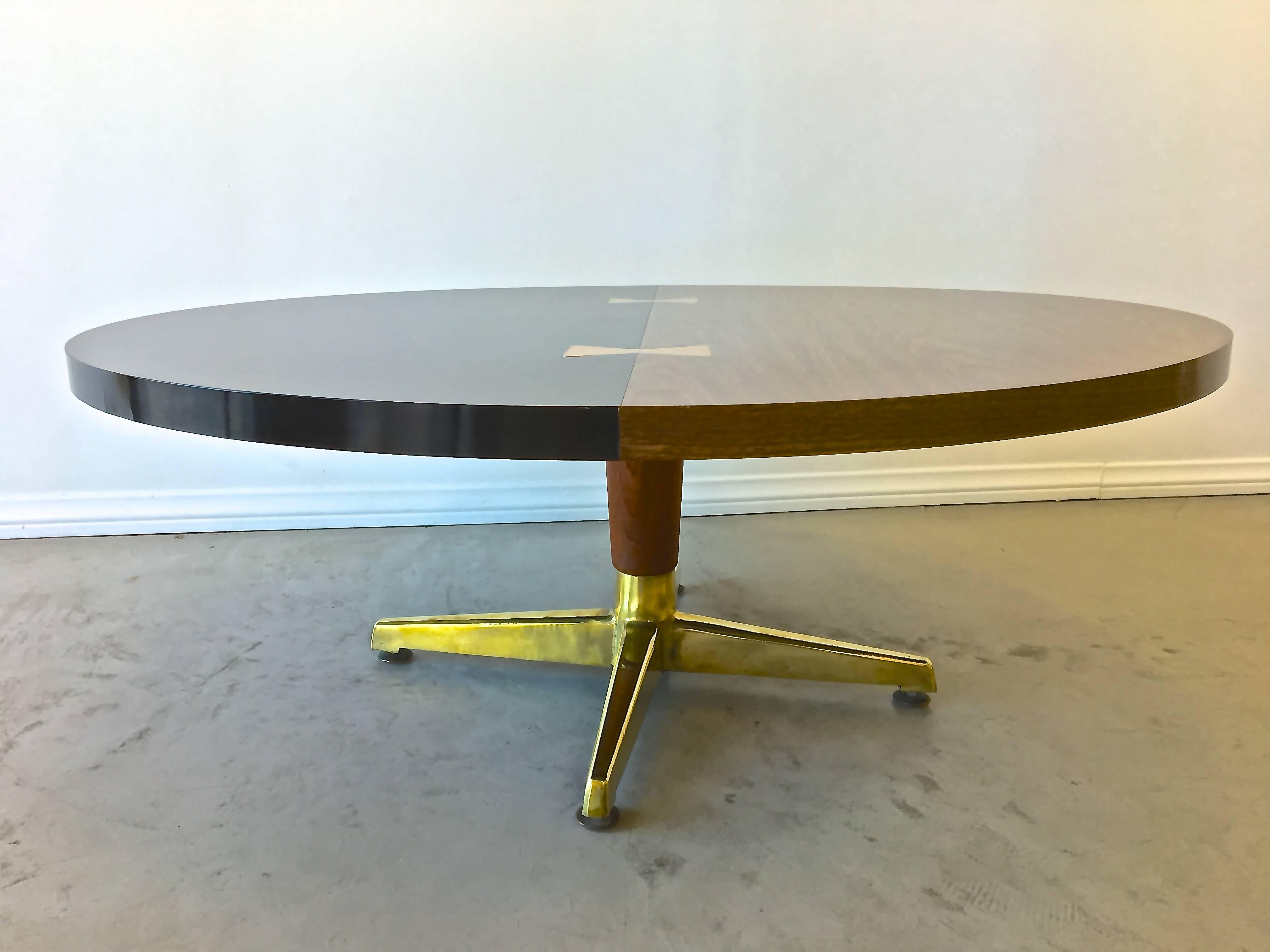 Brass inlaid "bow ties" dress up the split laminate top of ebony and faux walnut while giving a wink to the handcrafted hardwood tables prevalent mid-century. Top is supported by a stem of solid real walnut with a splay of four polished