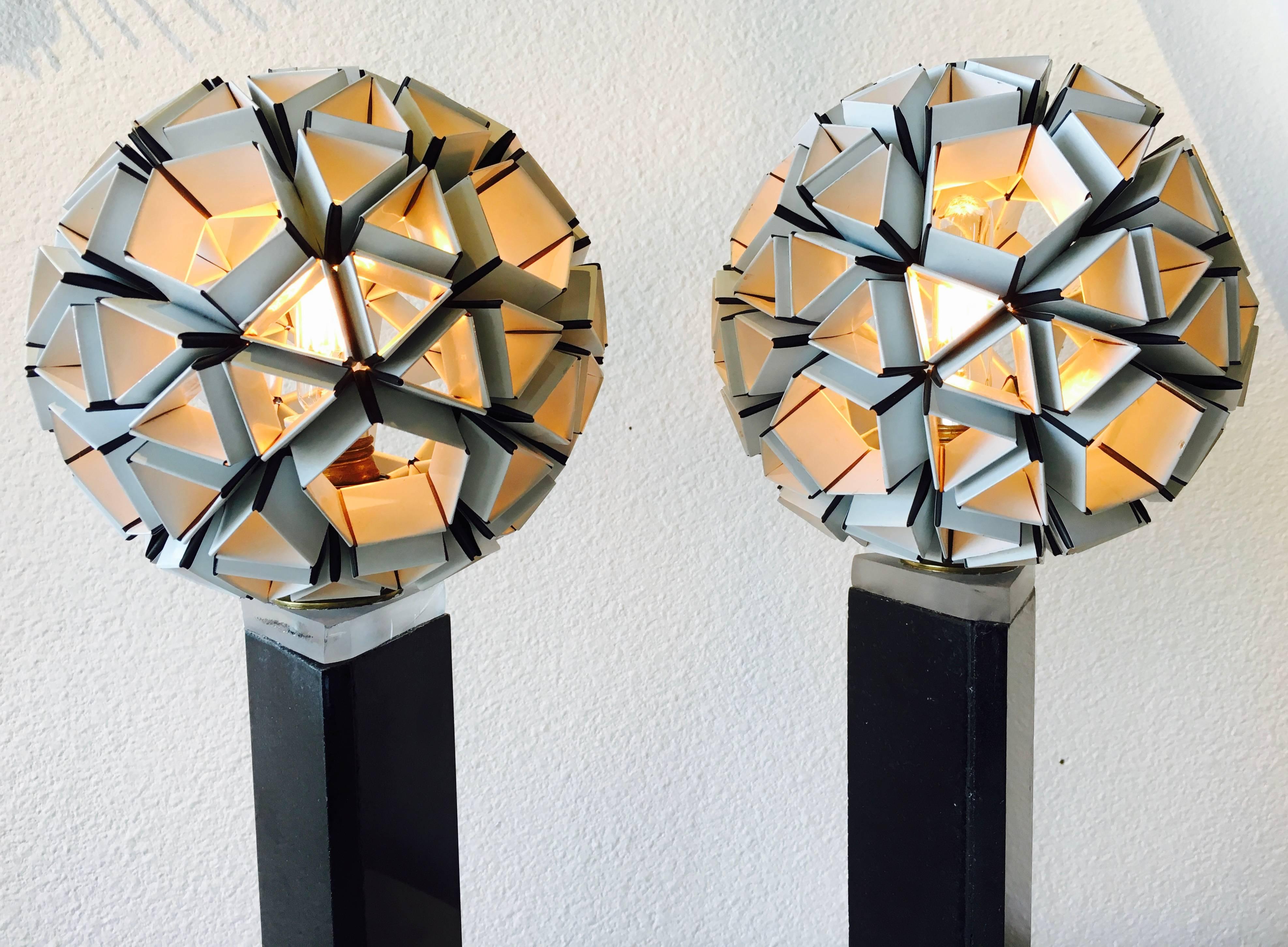 One-of-a-kind, handcrafted pair of sculptural table lamps evoke the fragile beauty of dandelions. White Origami lighted blooms adjoin to black marble columns with Lucite spacers between. Triangular bases balance the lighted sculptures.