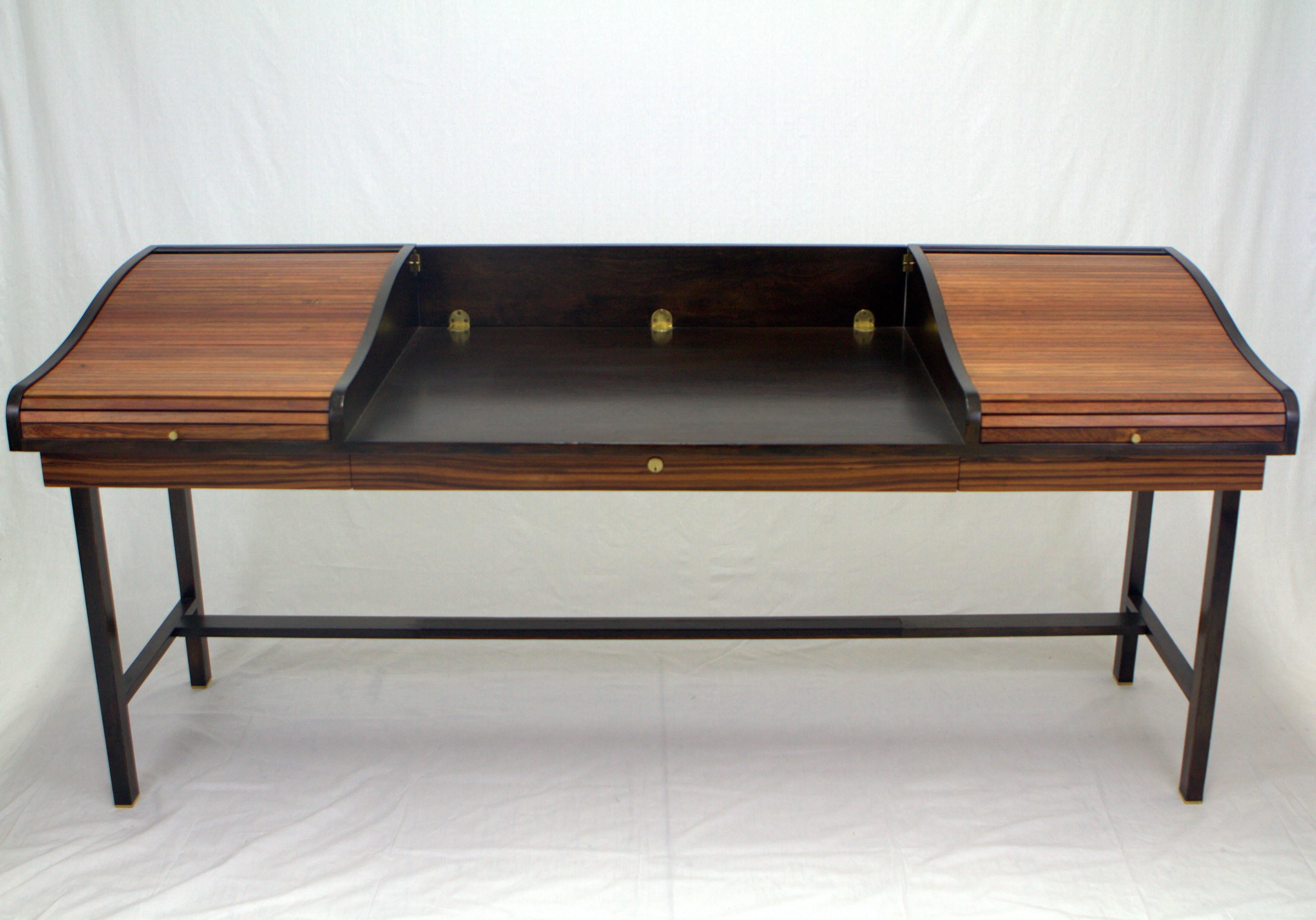 Elegant mahogany and rosewood double roll-top partners desk by Edward Wormley for Dunbar. Two roll-tops open to conceal small drawers on the left and an open space on the right, these flank a hinged panel that drops allowing it to be used as a