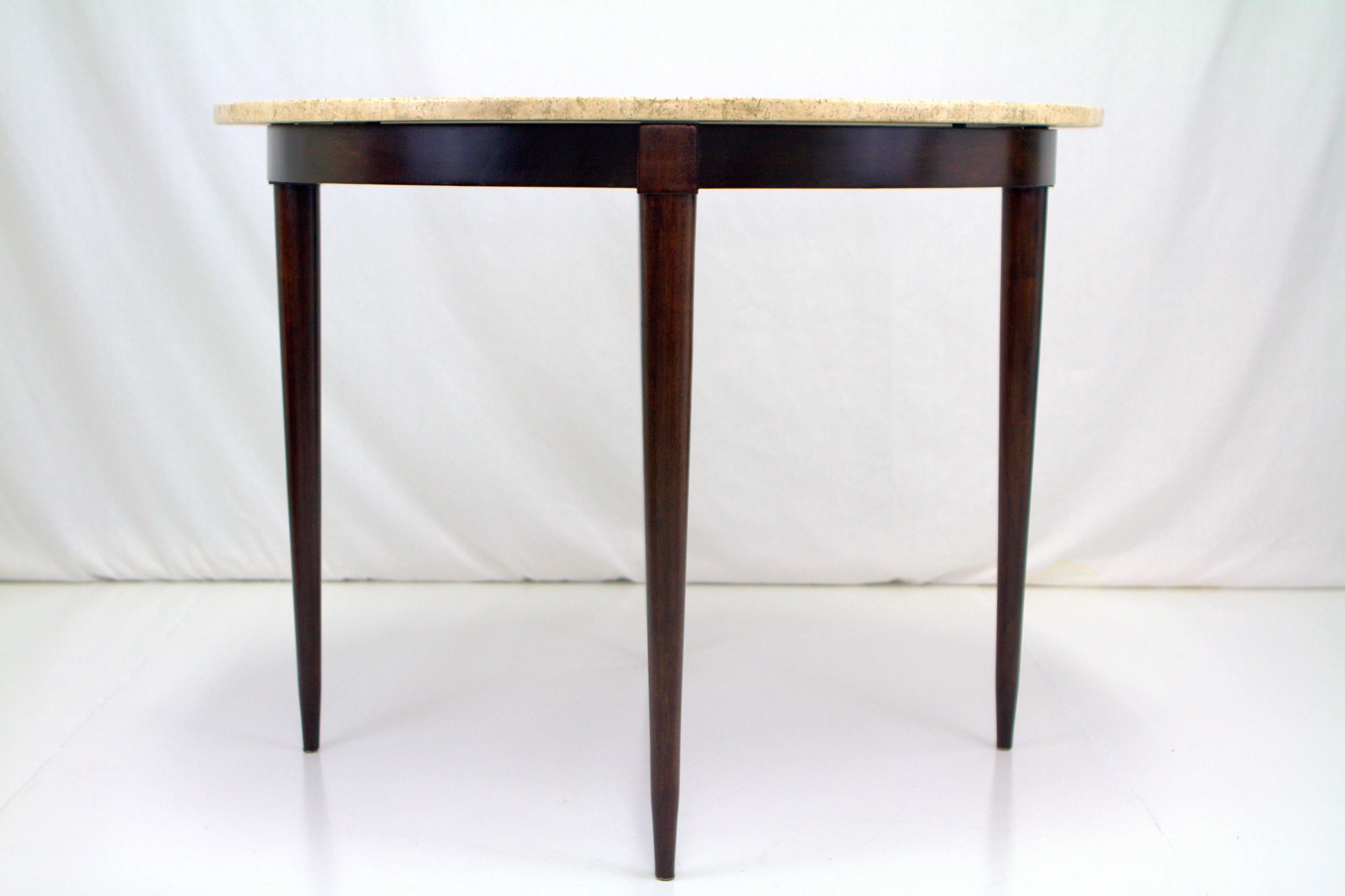 Elegant Italian travertine marble Gio Ponti style dining/center table. Round marble sits on java stained walnut base with slender tapered legs emanating from squared block on apron.