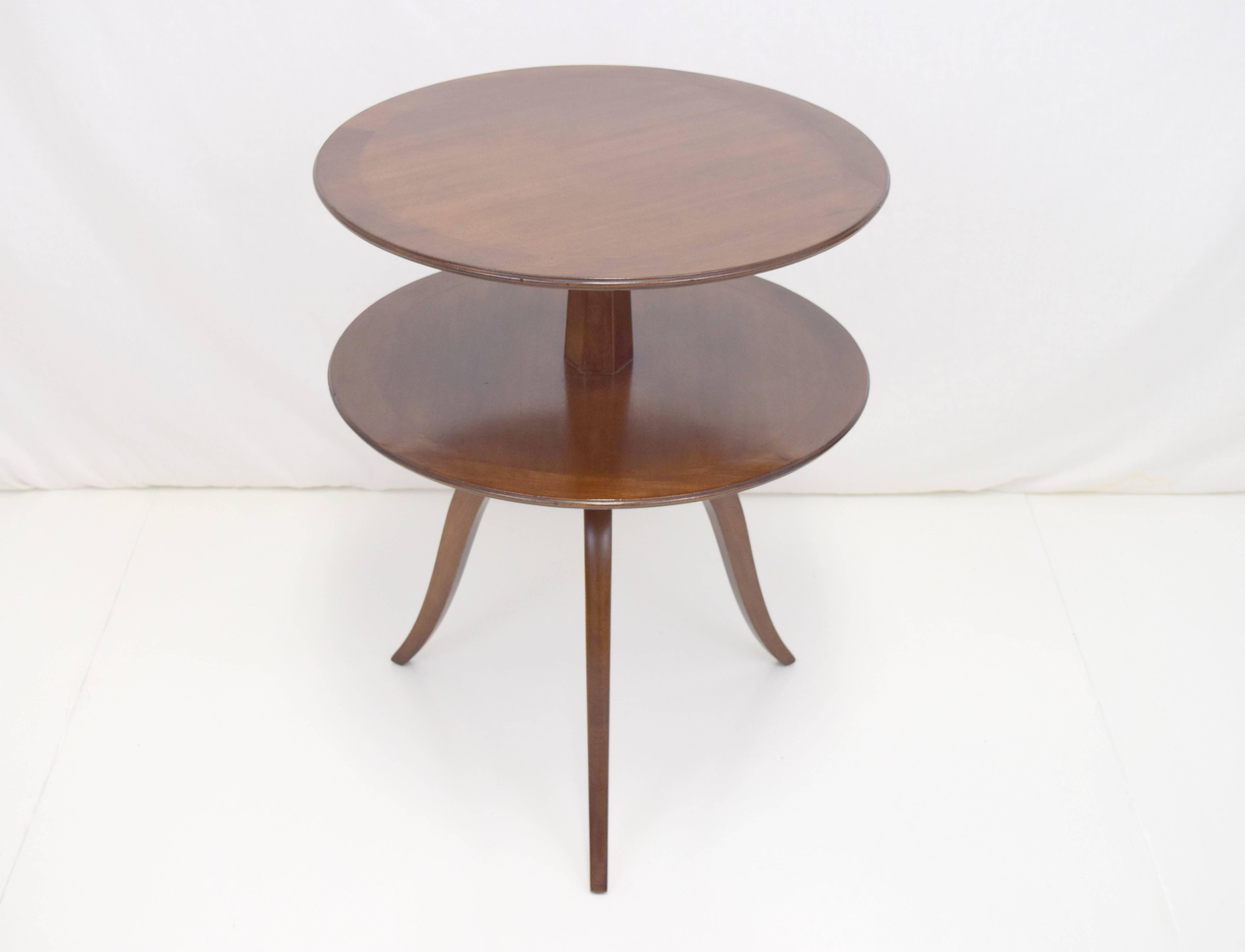 Elegant round tiered table by Edward Wormley for Dunbar. Banded edge surfaces in mahogany with gently curved legs.