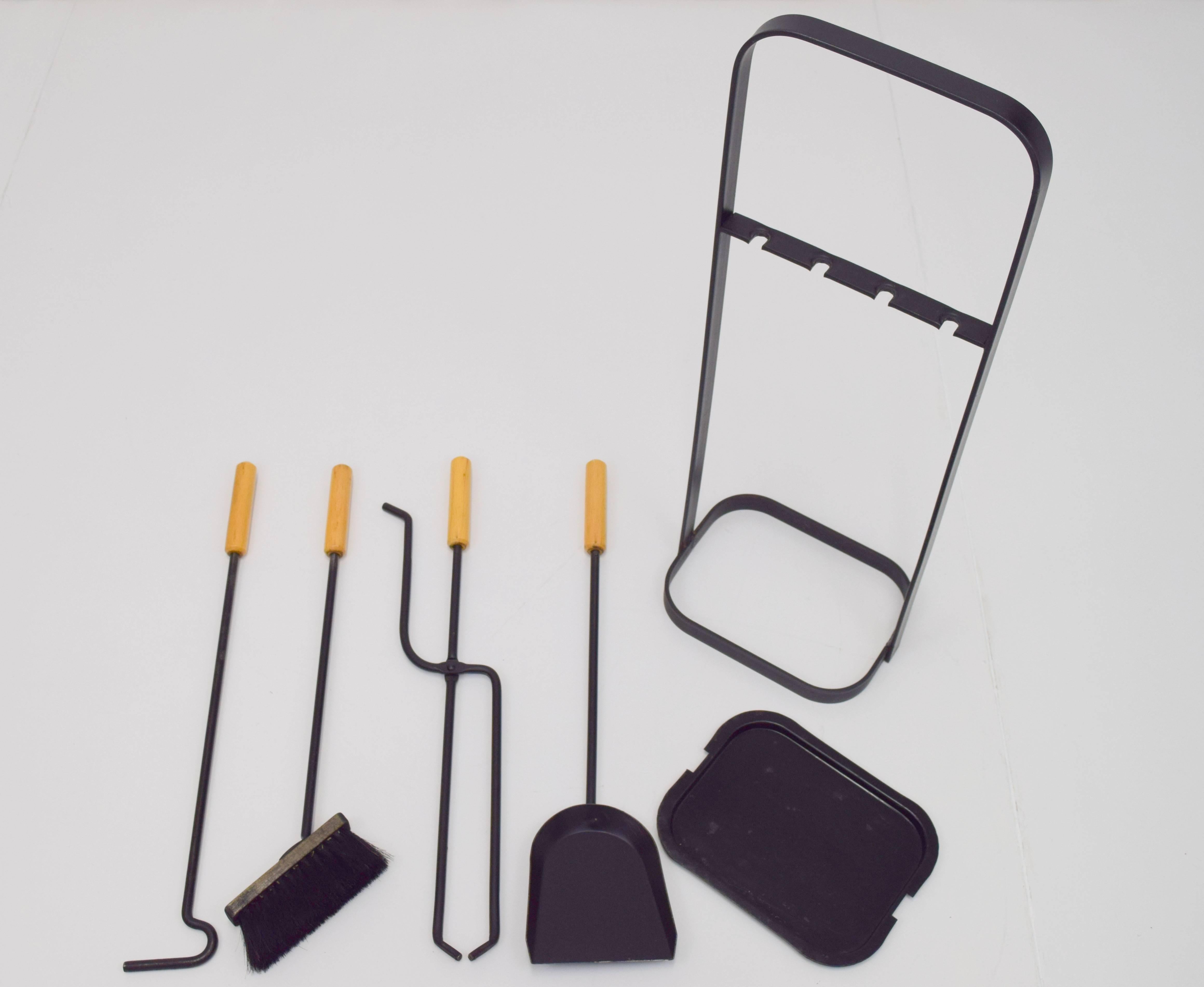 George Nelson like fire tools made in Austria. Modernist frame and tools executed in wrought iron and birch. Set includes holder, broom, dustpan, log grabber, and poker. Removable bottom tray for easier clean up. Retains manufacturers tag to inner