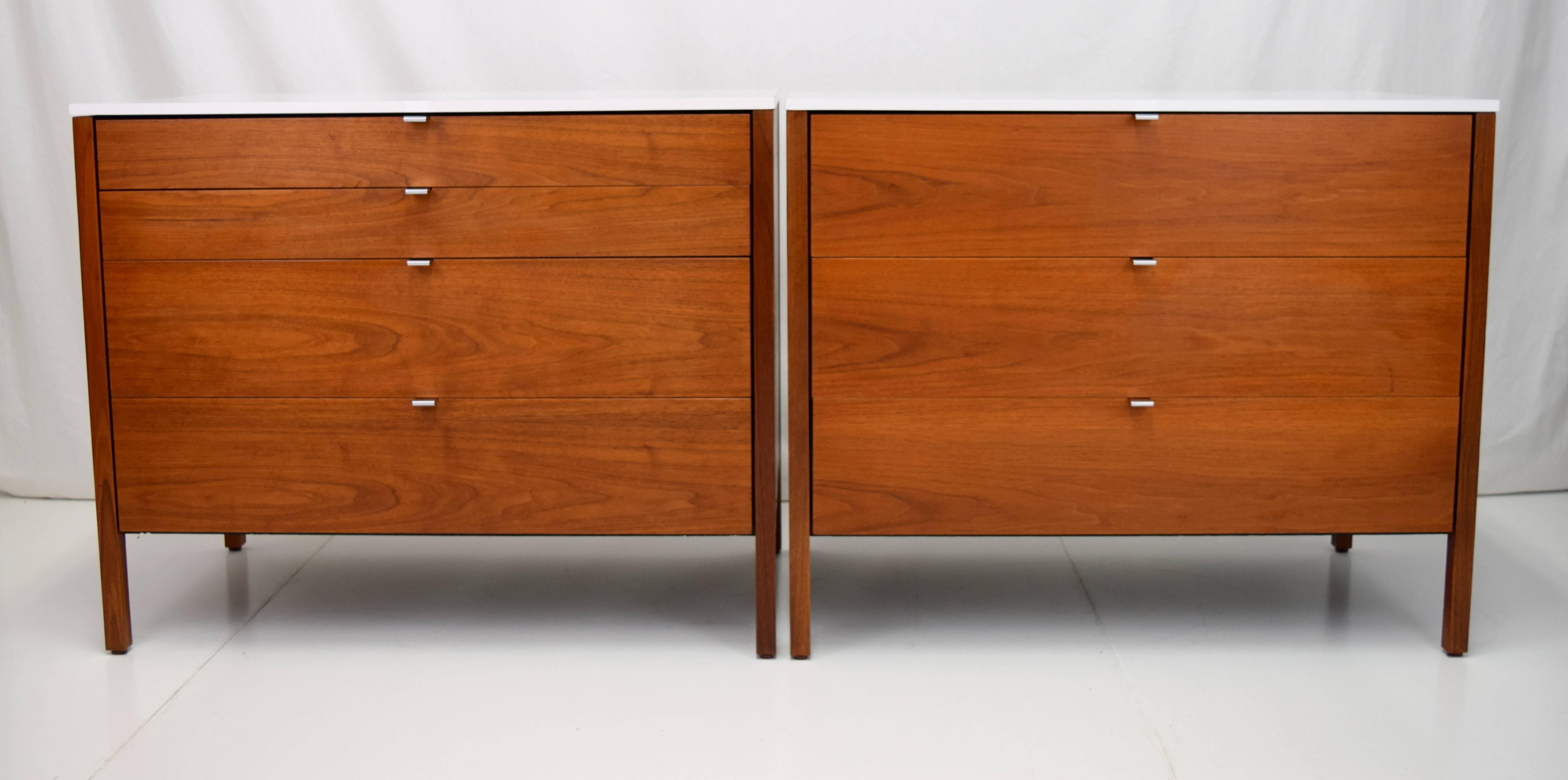 Fantastic walnut and white laminate dresser set by Florence Knoll. Set consist of one three-drawer chest, one four-drawer chest, and a removable single drawer desk/ vanity. Elegant polished chrome recessed pulls gleam from original walnut frame with