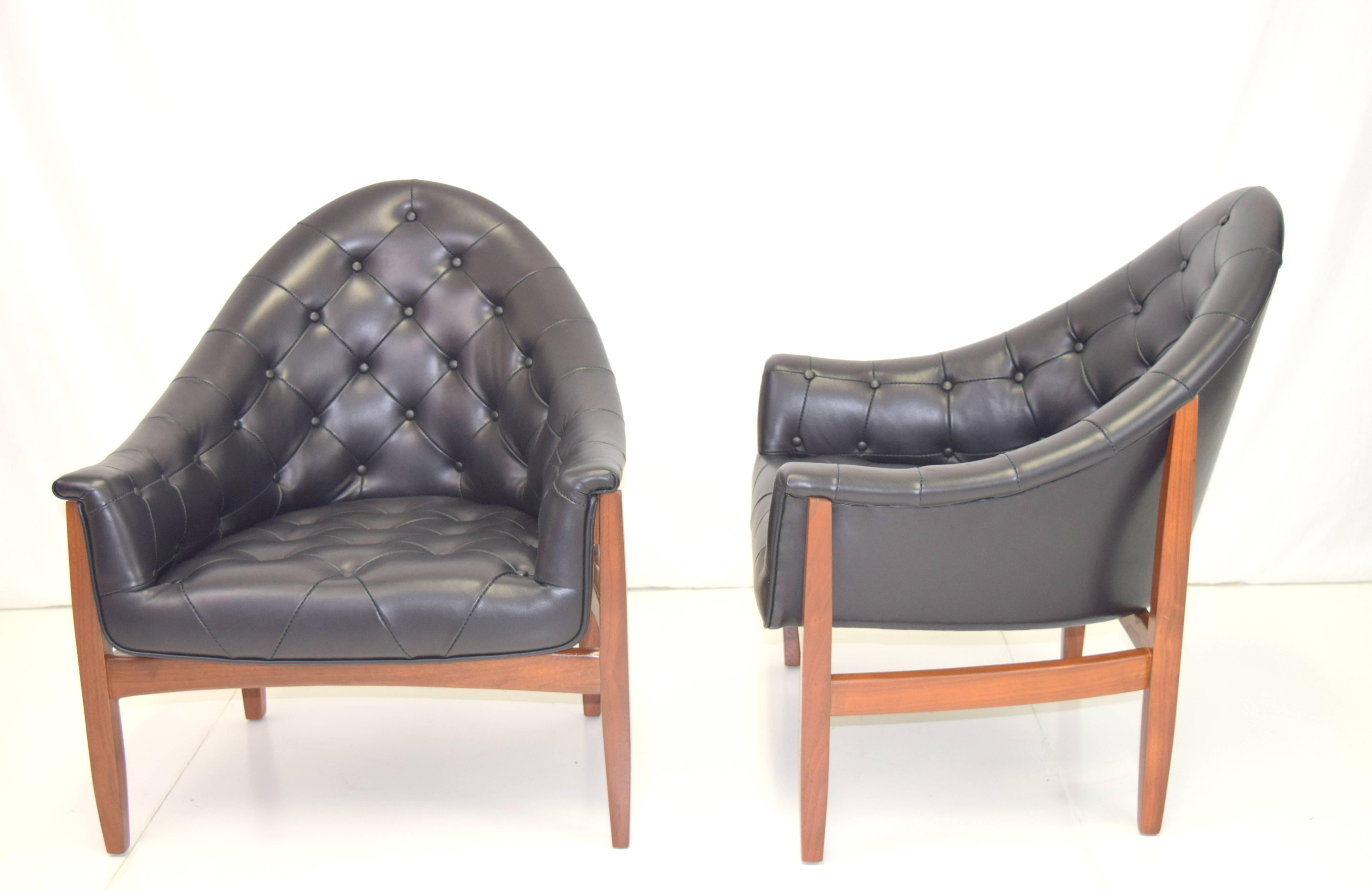 Rare pair of walnut framed tufted chairs by Milo Baughman. Professionally rebuilt and upholstered in black leather and refinished walnut frames. Sexy silhouettes and scale.