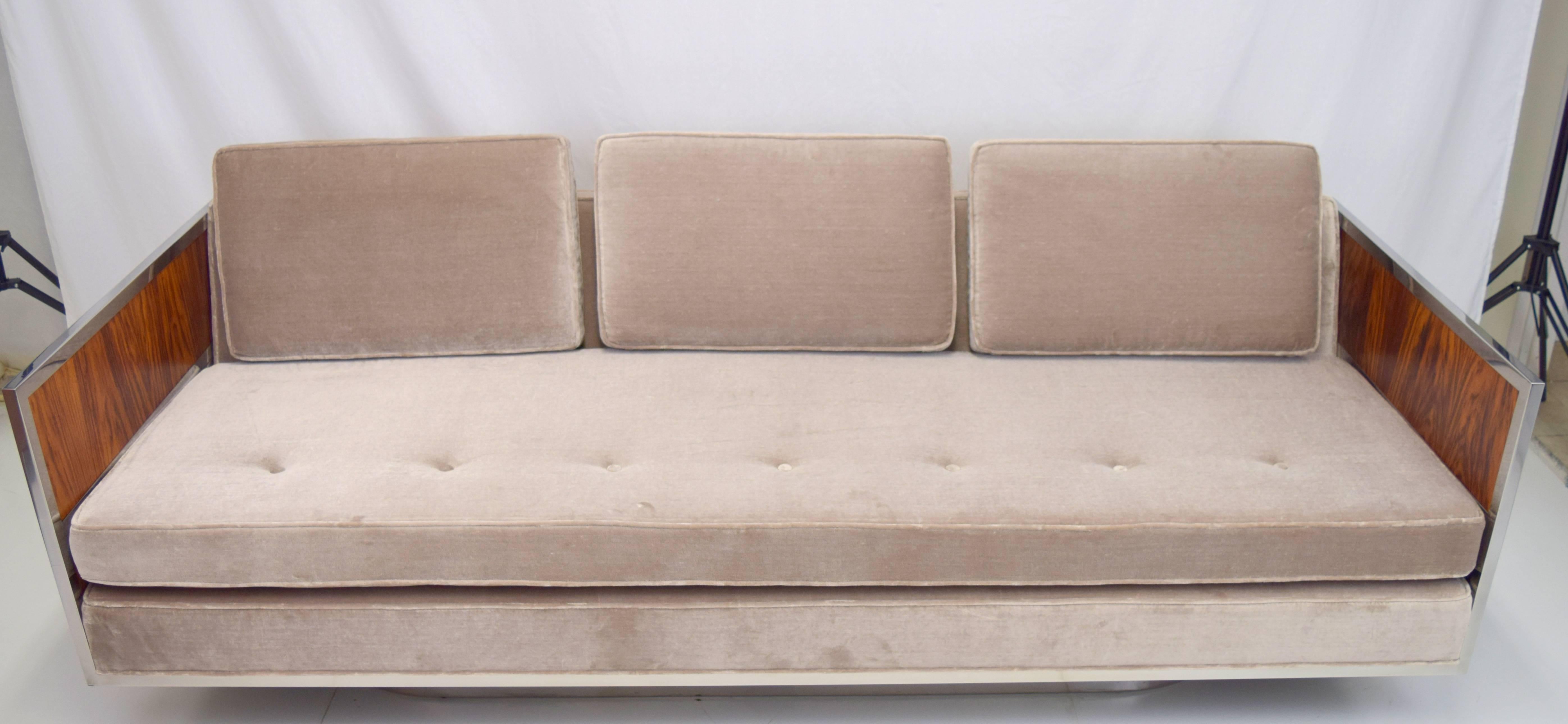 Amazing modernist case sofa attributed to Milo Baughman with rosewood and chrome side panels. Professionally rebuilt and upholstered frame in silver velvet with new cushions and webbing. Sleek oval chrome base and dramatic rosewood grain compliments