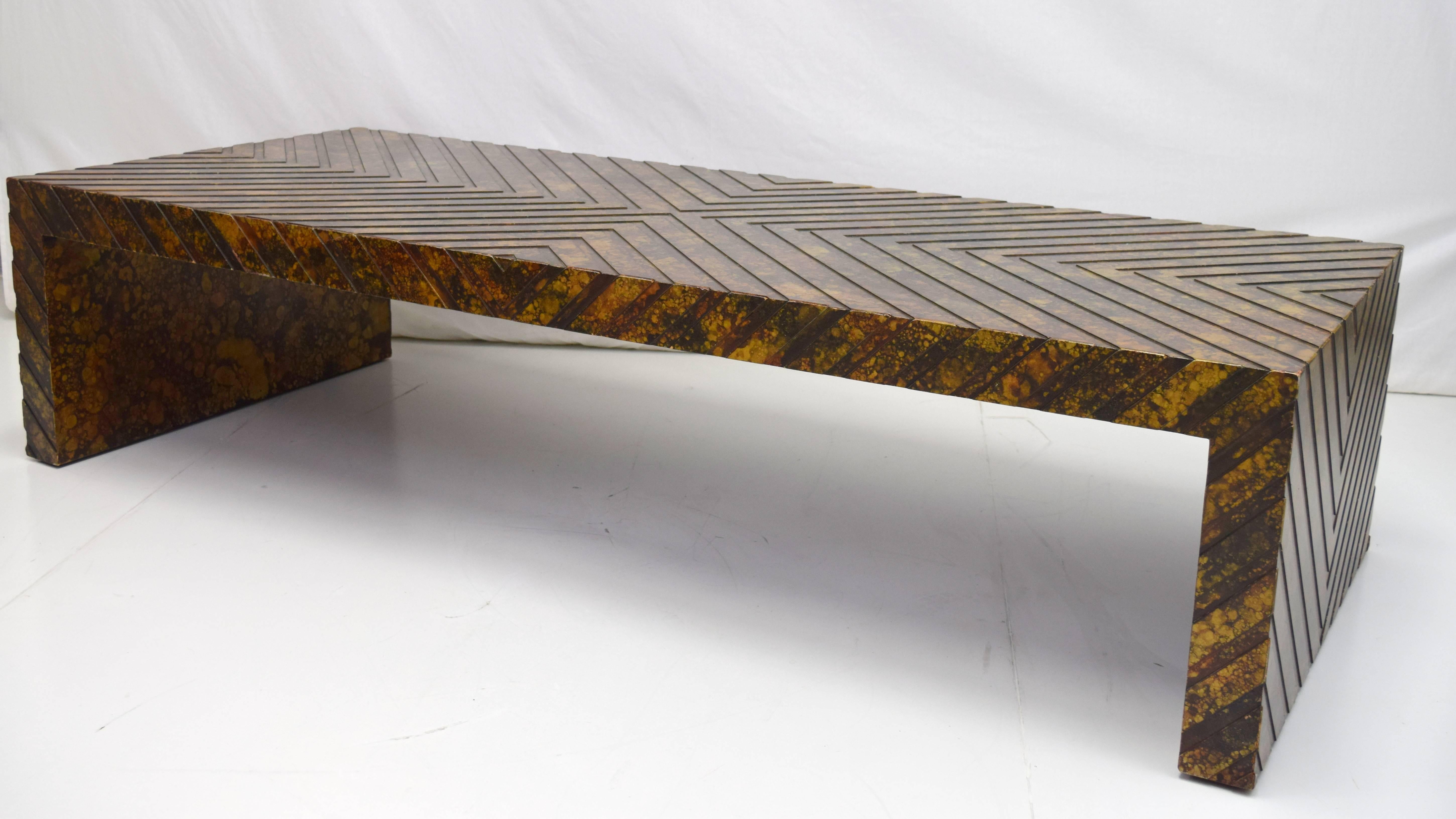 Large-scale chevron patterned cocktail table in oil drop or faux tortoiseshell finish by Phyllis Morris. Nesting footstools with removable vinyl pads in matching finish. Inscribed signature on inside of one leg. Footstool dimensions 21" square