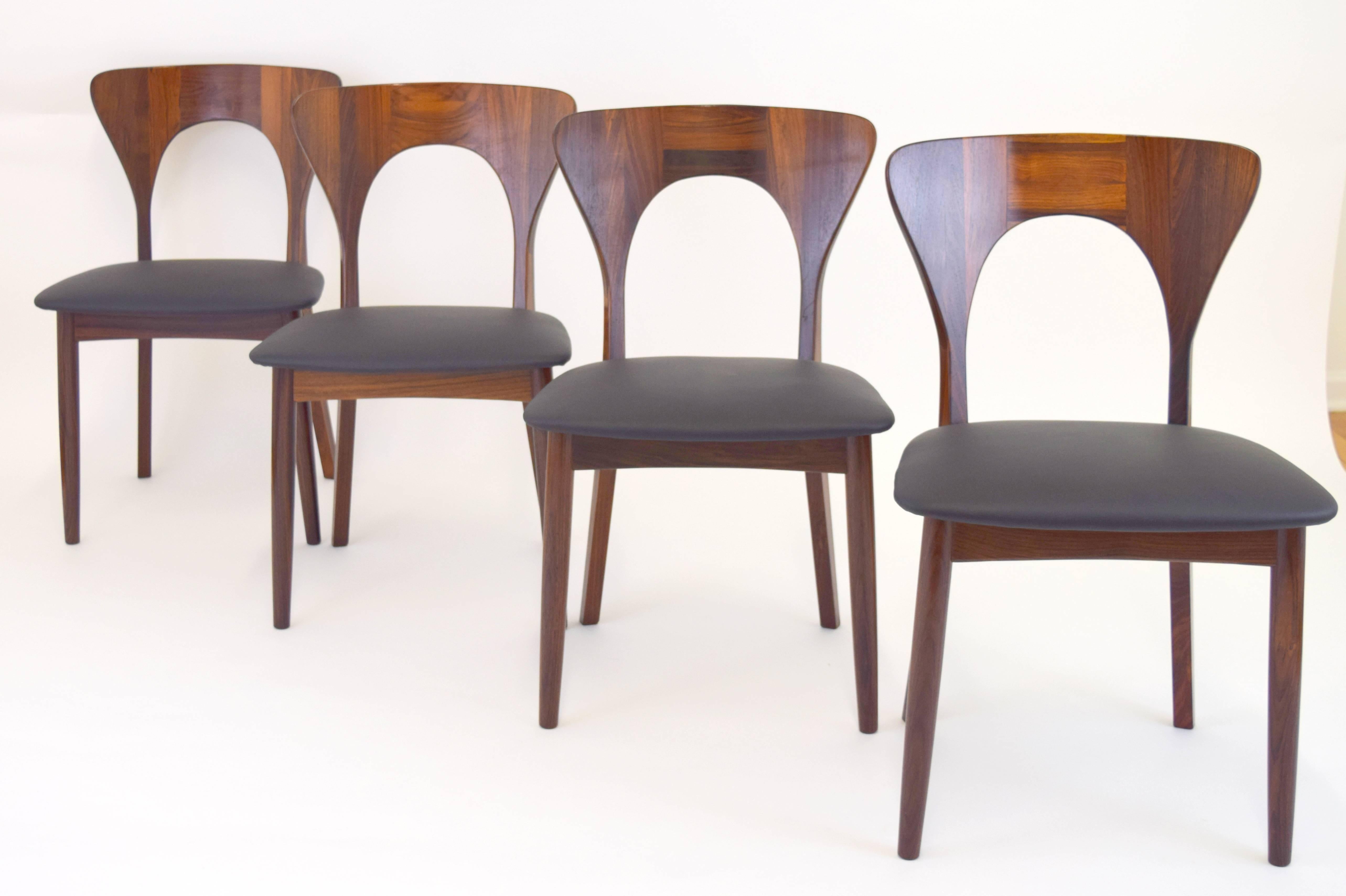 Stunning set of four rosewood Peter chairs by Niels Koefoed for Koefoeds Hornslet. Introduced in 1957 the Peter chair is an elegant example Danish design. Striking rosewood grain beautifully flows with graceful lines of chair. Seats are newly