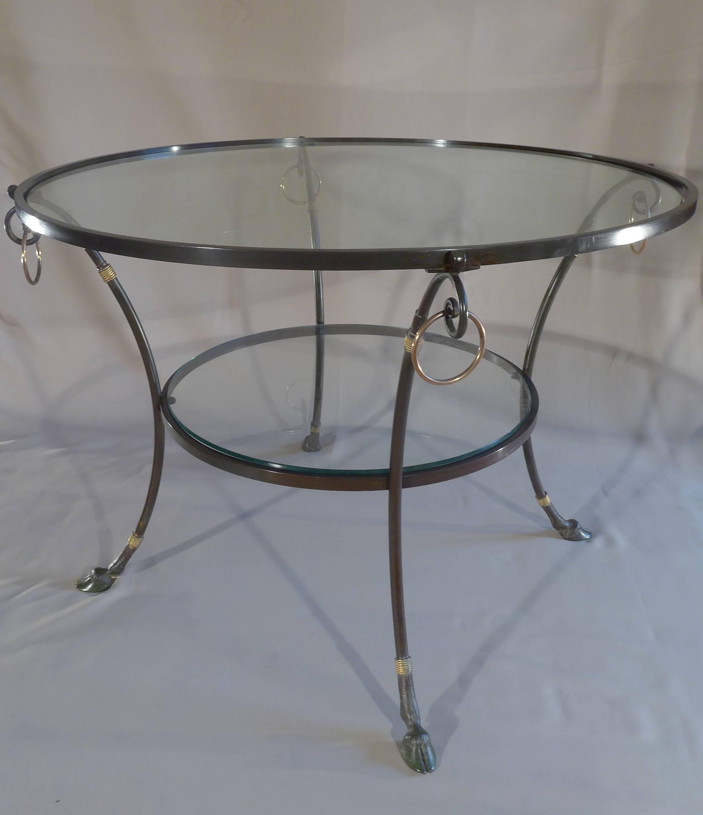 French design, late 20h century iron patinated, hoop ring details, curved legs terminated by animal hoofs, glass top,
circa 1960-1970.
Dimensions: 21.25 in. H, 30.70 in. W.