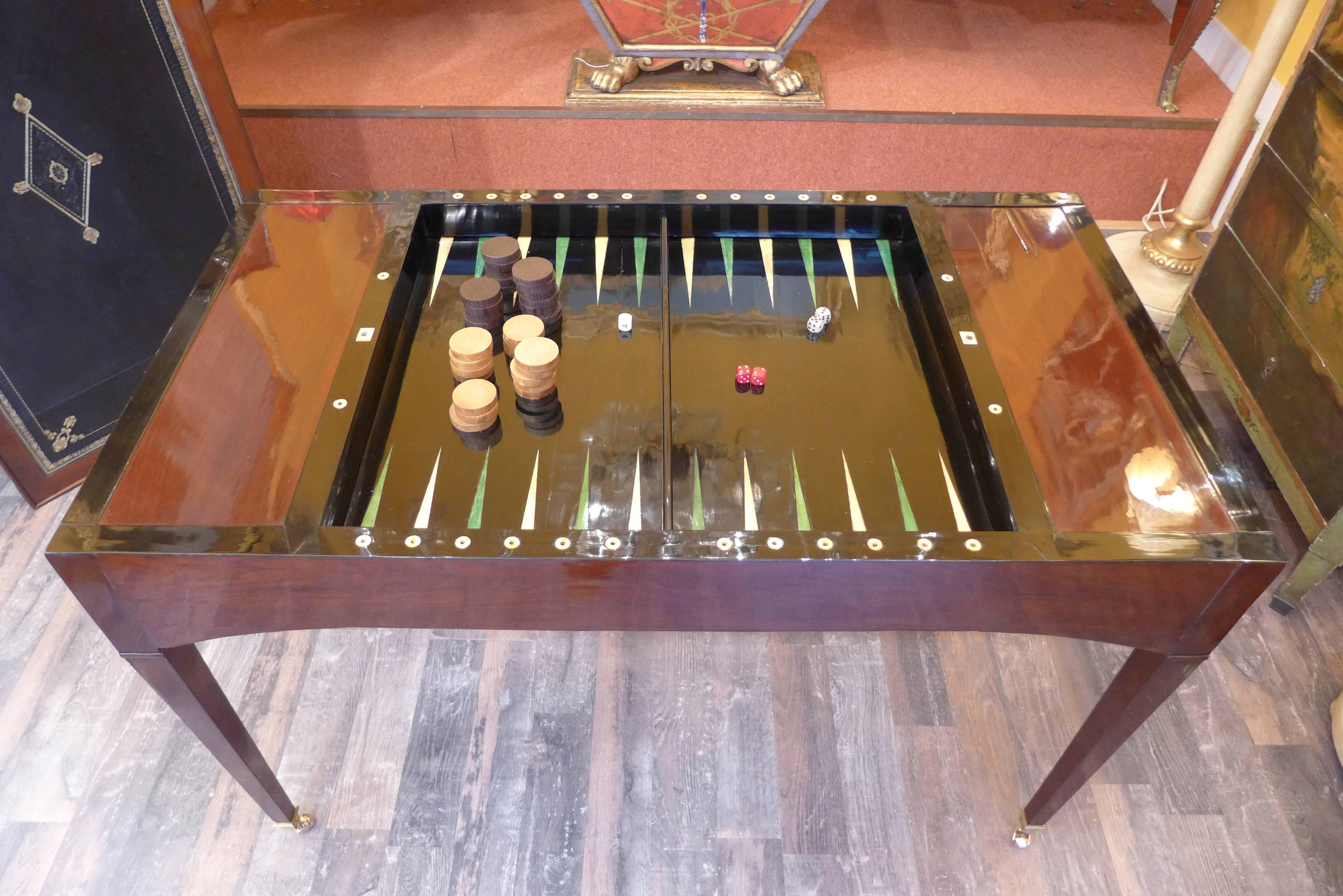 French Directoire period Tric-Trac or “Jeu de Jacquet “ game table in mahogany and mahogany veneer. Very practical removal and reversible top with handsome decorated new leather. One side serves as a small desk and the reverse side of the tabletop